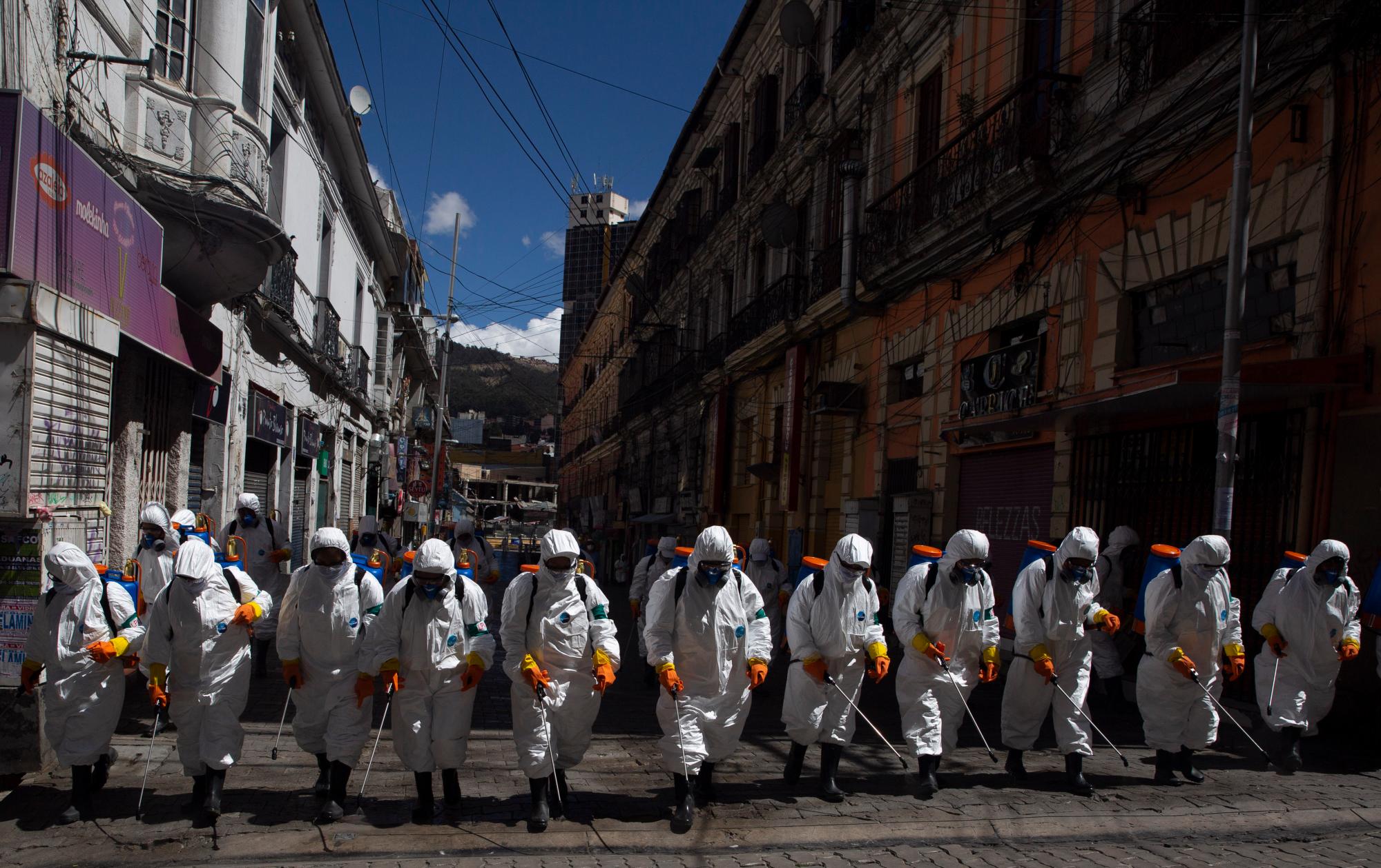 En esta imagen, tomada el 2 de abril de 2020, operarios municipales fumigan una calle como medida de precaución contra el coronavirus, en La Paz, Bolivia. El ministro de Salud confirmó la primera muerte por coronavirus en el país, una mujer de 78 años que falleció por un fallo respiratorio grave. (AP Foto/Juan Karita)