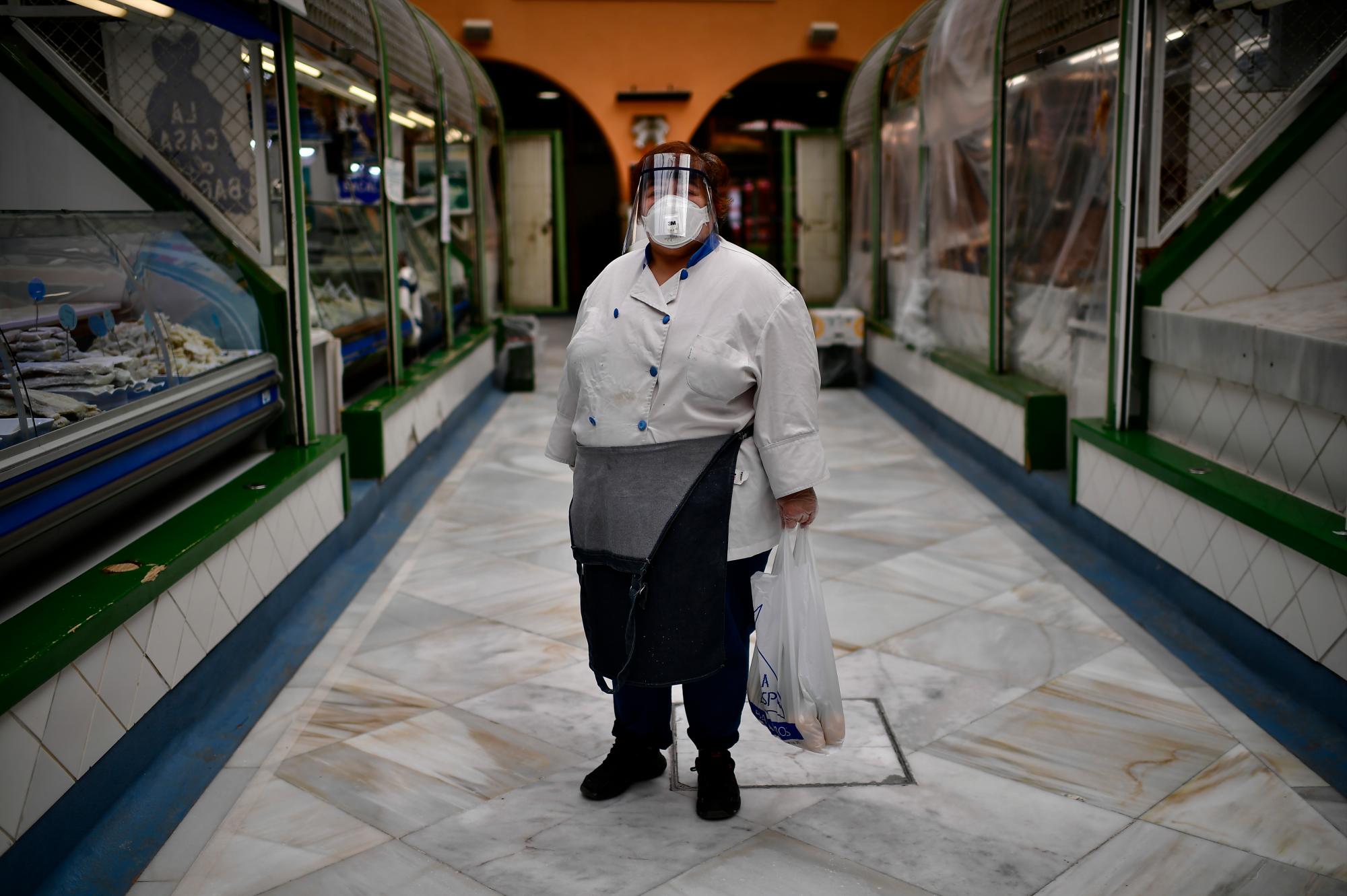 En esta imagen del martes 14 de abril de 2020, Juana Mari posa para una foto junto a su pescadería en un mercado en Pamplona, en el norte de España. (AP Foto/Álvaro Barrientos)