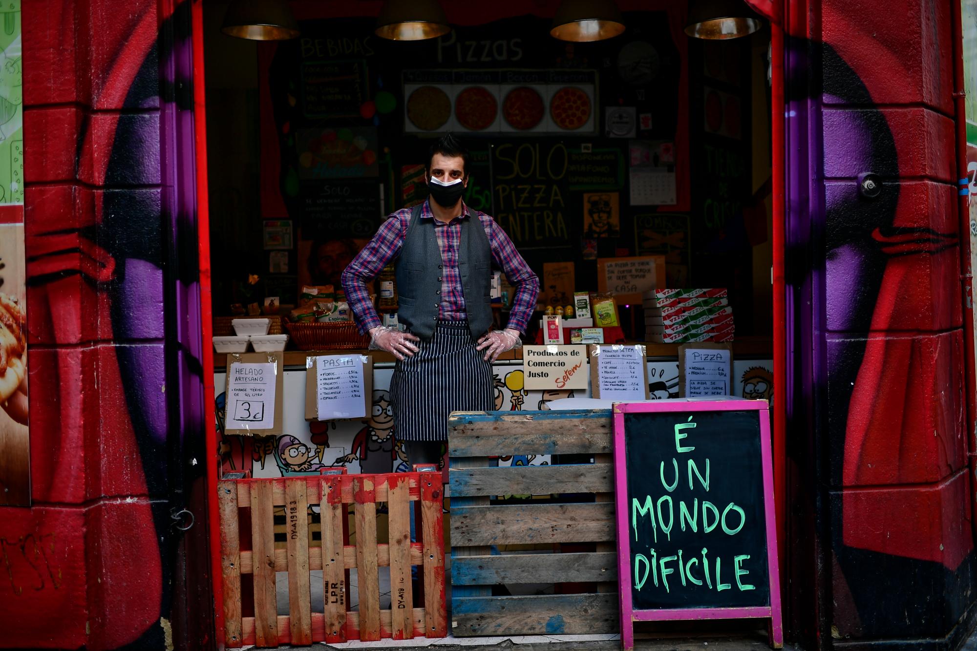 En esta imagen del martes 14 de abril de 2020, Miguel Ángel Pena posa para una foto en su tienda de alimentación en Pamplona, en el norte de España. (AP Foto/Alvaro Barrientos)