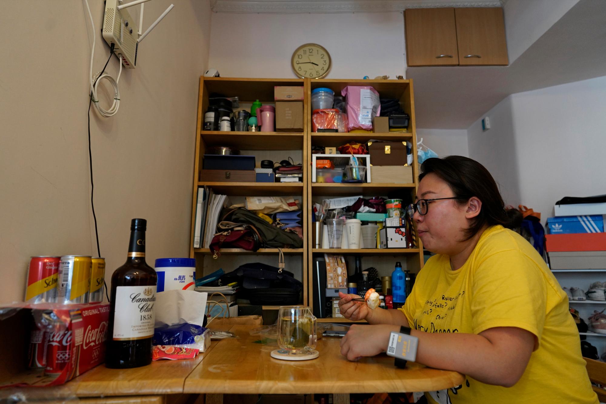 La reportera de Associated Press, Zen Soo, come su almuerzo en la mesa del comedor en su casa mientras sirve una cuarentena domiciliaria de dos semanas en Hong Kong, el 17 de abril de 2020. Hong Kong emitió pulseras de cuarentena para monitorear a los residentes que regresan de la ciudad mientras cumplen su obligación 14 cuarentena diaria, en un intento por frenar las transmisiones locales de COVID-19 durante la pandemia. (Foto AP / Vincent Yu)