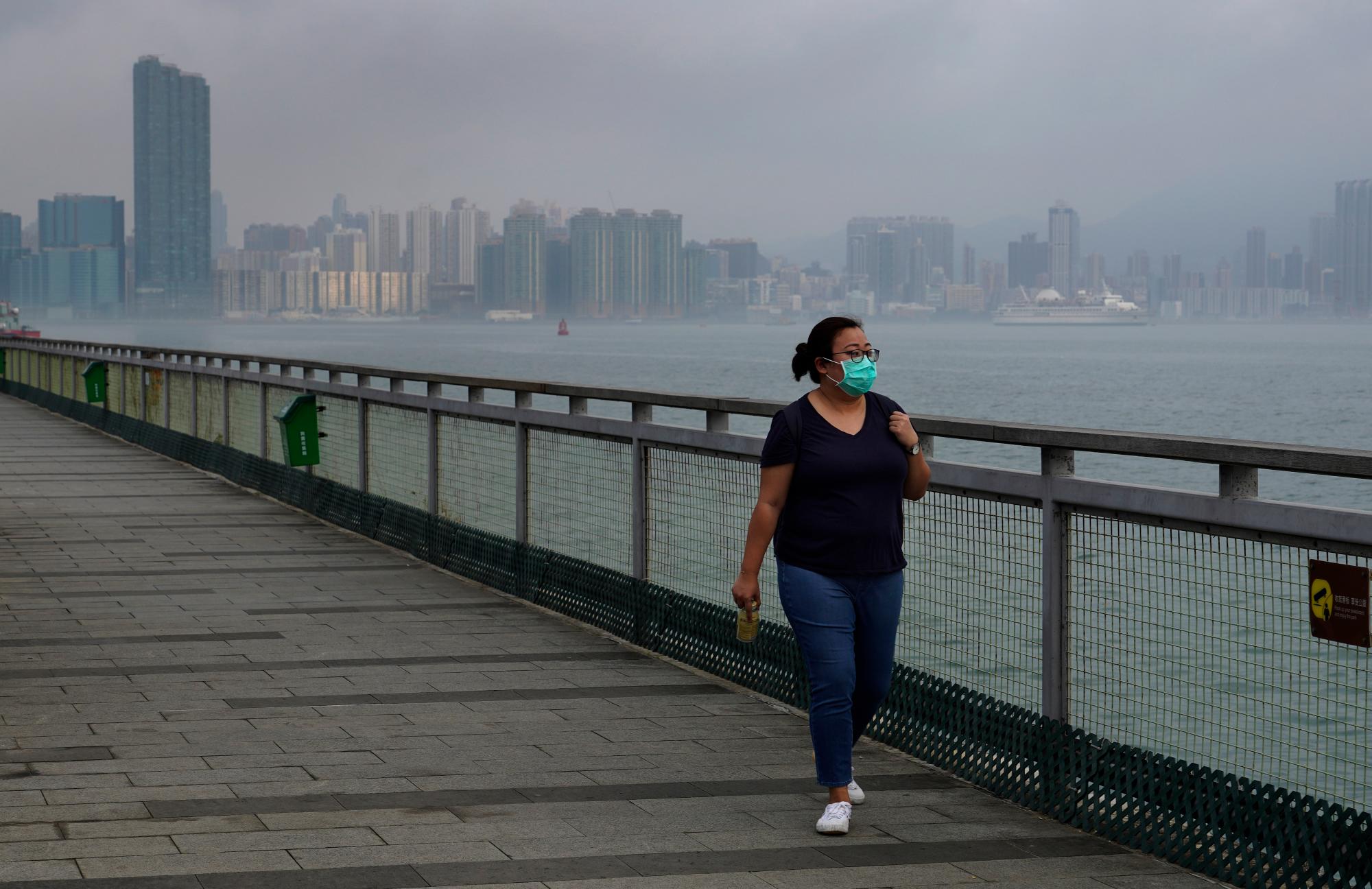 El periodista de Associated Press, Zen Soo, camina a lo largo de Quarry Bay Promenade en Hong Kong el primer día de libertad después de 14 días de cuarentena domiciliaria en Hong Kong, el 19 de abril de 2020. (Foto AP / Vincent Yu)