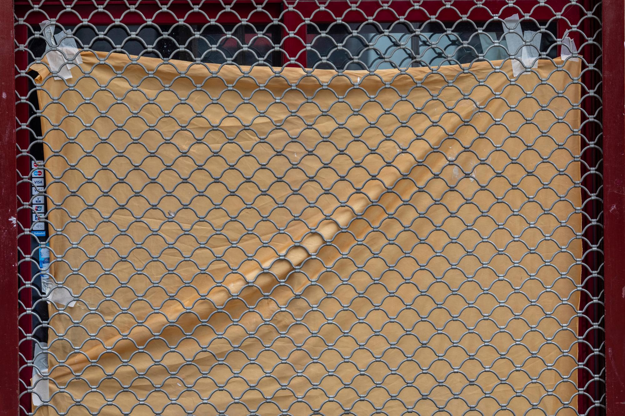 En esta foto del martes 21 de abril de 2020, una hoja cubre los productos de un escaparate de un negocio cerrado durante el brote de coronavirus en Madrid, España. La Confederación Española de Comercio, que representa a miles de pequeñas empresas, dice que hasta el 30% de ellas en todo el país cerrarán sus puertas para siempre a menos que reciban ayuda financiera del gobierno. (Foto AP / Bernat Armangue)