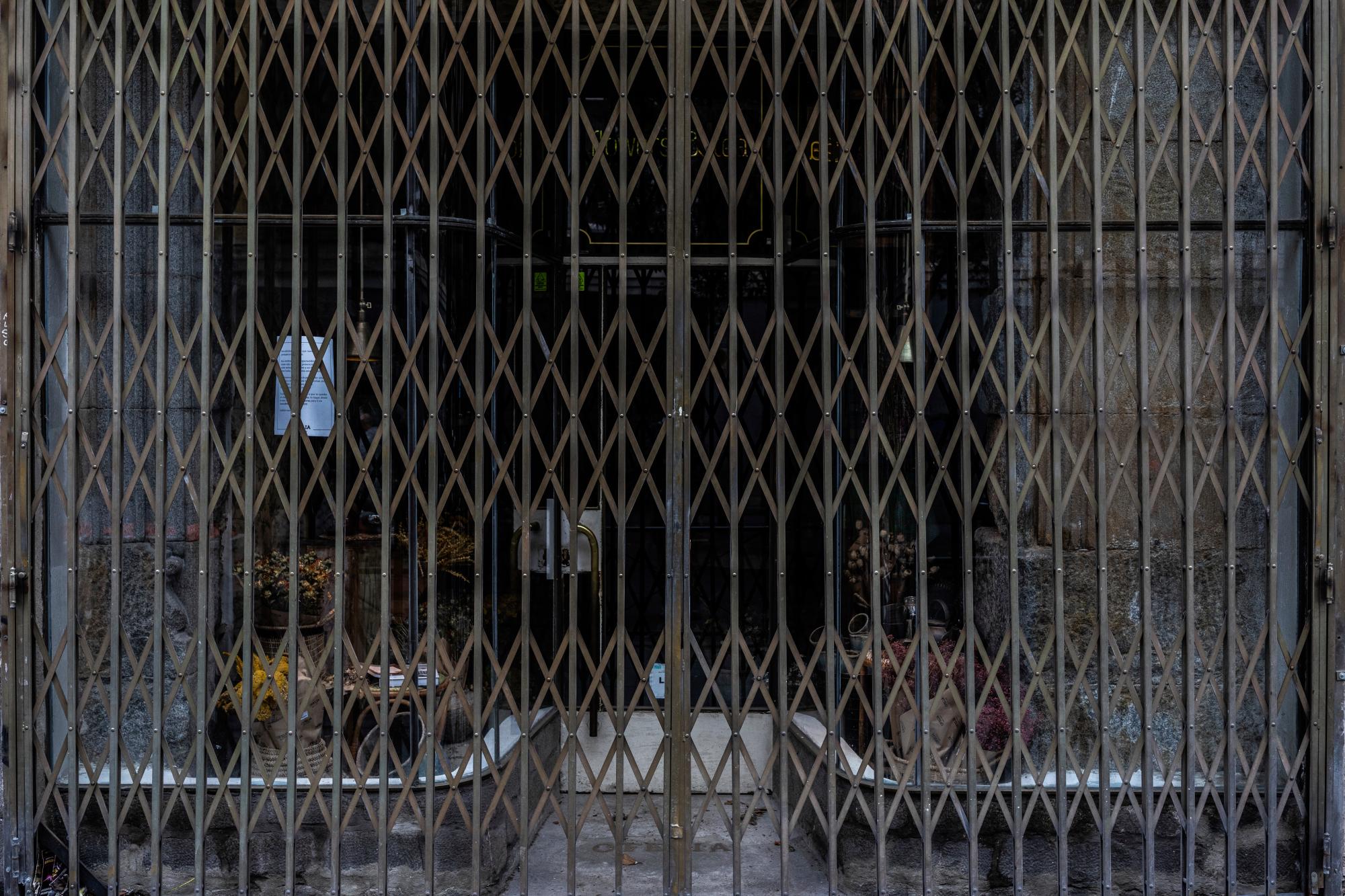 En esta foto del lunes 20 de abril de 2020, detalle de la entrada de una tienda cerrada durante el brote de coronavirus en Madrid, España. La Confederación Española de Comercio, que representa a miles de pequeñas empresas, dice que hasta el 30% de ellas en todo el país cerrarán sus puertas para siempre a menos que reciban ayuda financiera del gobierno. Las autoridades españolas están relajando gradualmente las medidas de confinamiento, pero aún no se sabe cuándo podrán reabrir las tiendas. (Foto AP / Bernat Armangue)