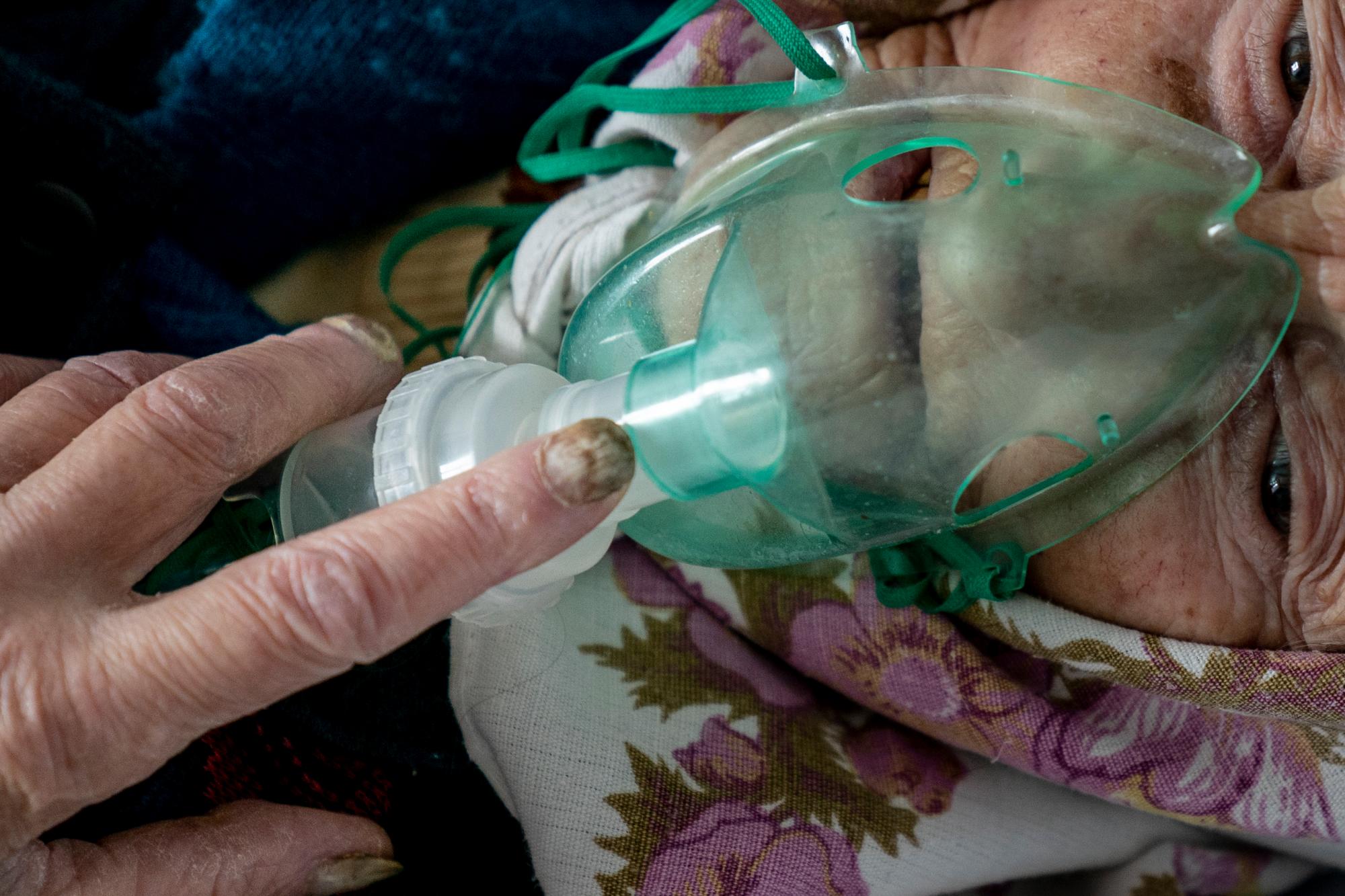 En esta foto tomada el viernes 1 de mayo de 2020, una anciana, una paciente con coronavirus, respira con una máscara de oxígeno dentro de un hospital en Pochaiv, Ucrania. El problemático sistema de salud de Ucrania ha sido abrumado por COVID-19, a pesar de que ha reportado un número relativamente bajo de casos. (Foto AP / Evgeniy Maloletka)