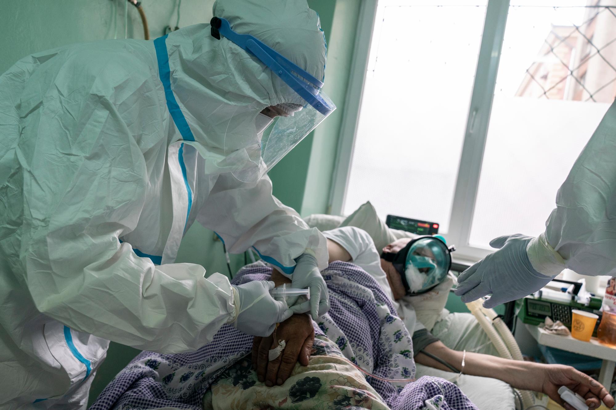 En esta foto tomada el lunes 4 de mayo de 2020, una enfermera, con un traje especial para protegerse contra el coronavirus, administra medicamentos a un paciente con coronavirus en una unidad de cuidados intensivos en un hospital regional en Chernivtsi, Ucrania. El problemático sistema de salud de Ucrania ha sido abrumado por COVID-19, a pesar de que ha reportado un número relativamente bajo de casos. (Foto AP / Evgeniy Maloletka)