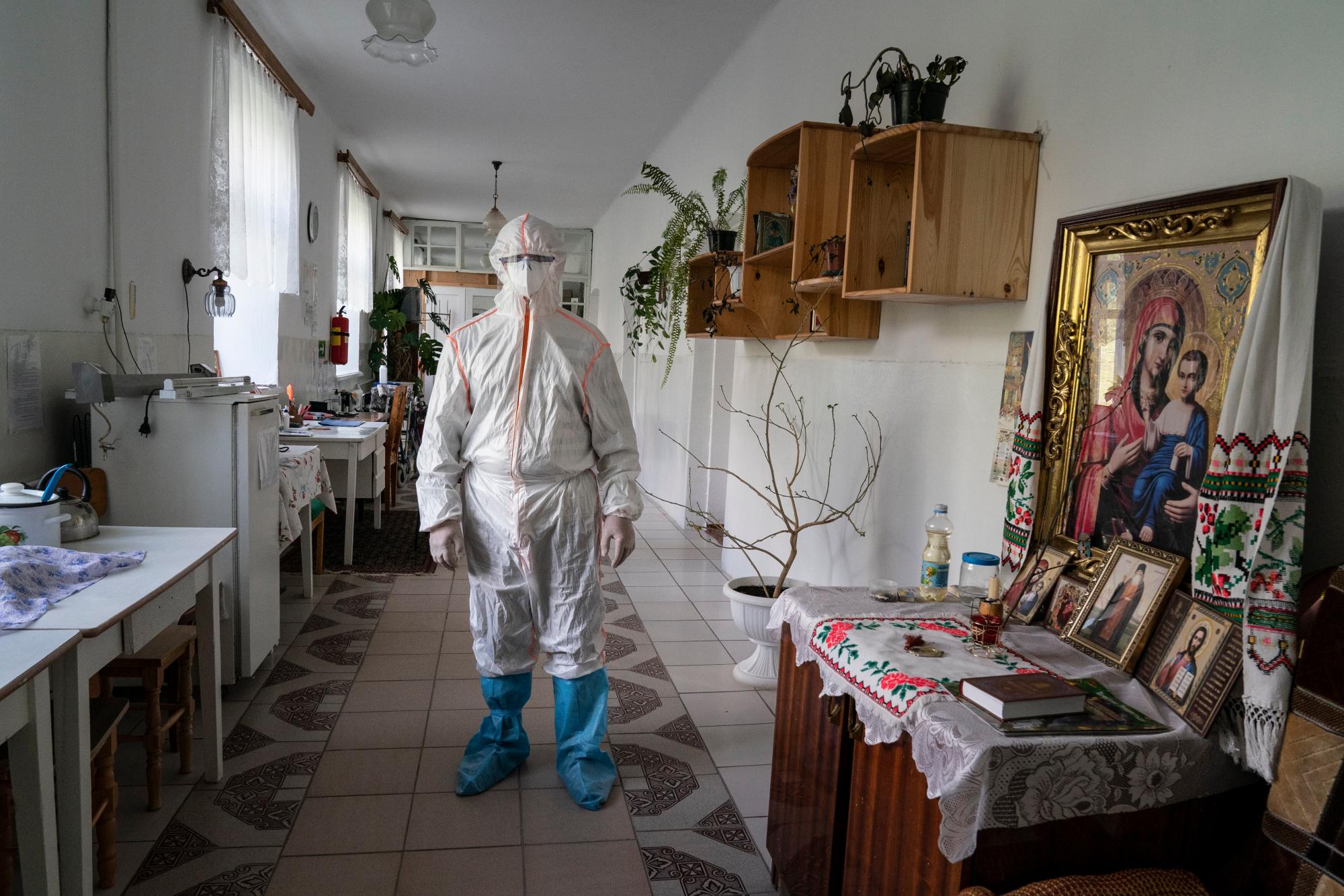 En esta foto tomada el viernes 1 de mayo de 2020, un especialista médico que usa un traje especial para protegerse contra el coronavirus, posa para una foto junto a un icono en un hospital en Pochaiv, Ucrania. El problemático sistema de salud de Ucrania ha sido abrumado por COVID-19, a pesar de que ha reportado un número relativamente bajo de casos. (Foto AP / Evgeniy Maloletka)