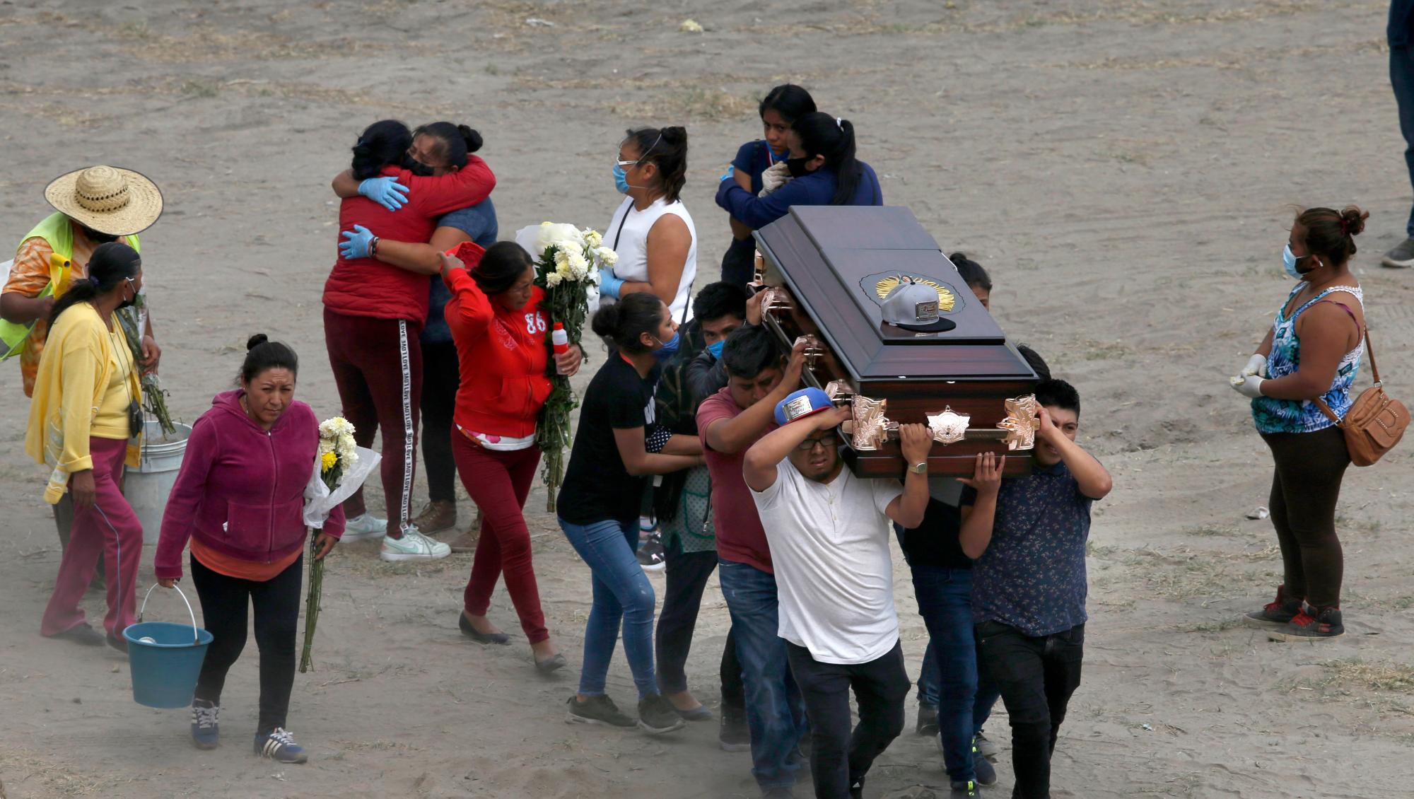 Los familiares llevan el ataúd que contiene los restos de un miembro de la familia en el recién construido Cementerio Municipal del Valle de Chalco, construido para dar cabida al aumento de las muertes en medio de la nueva pandemia de coronavirus, en las afueras de la Ciudad de México, el jueves 21 de mayo de 2020. ( Foto AP / Marco Ugarte)