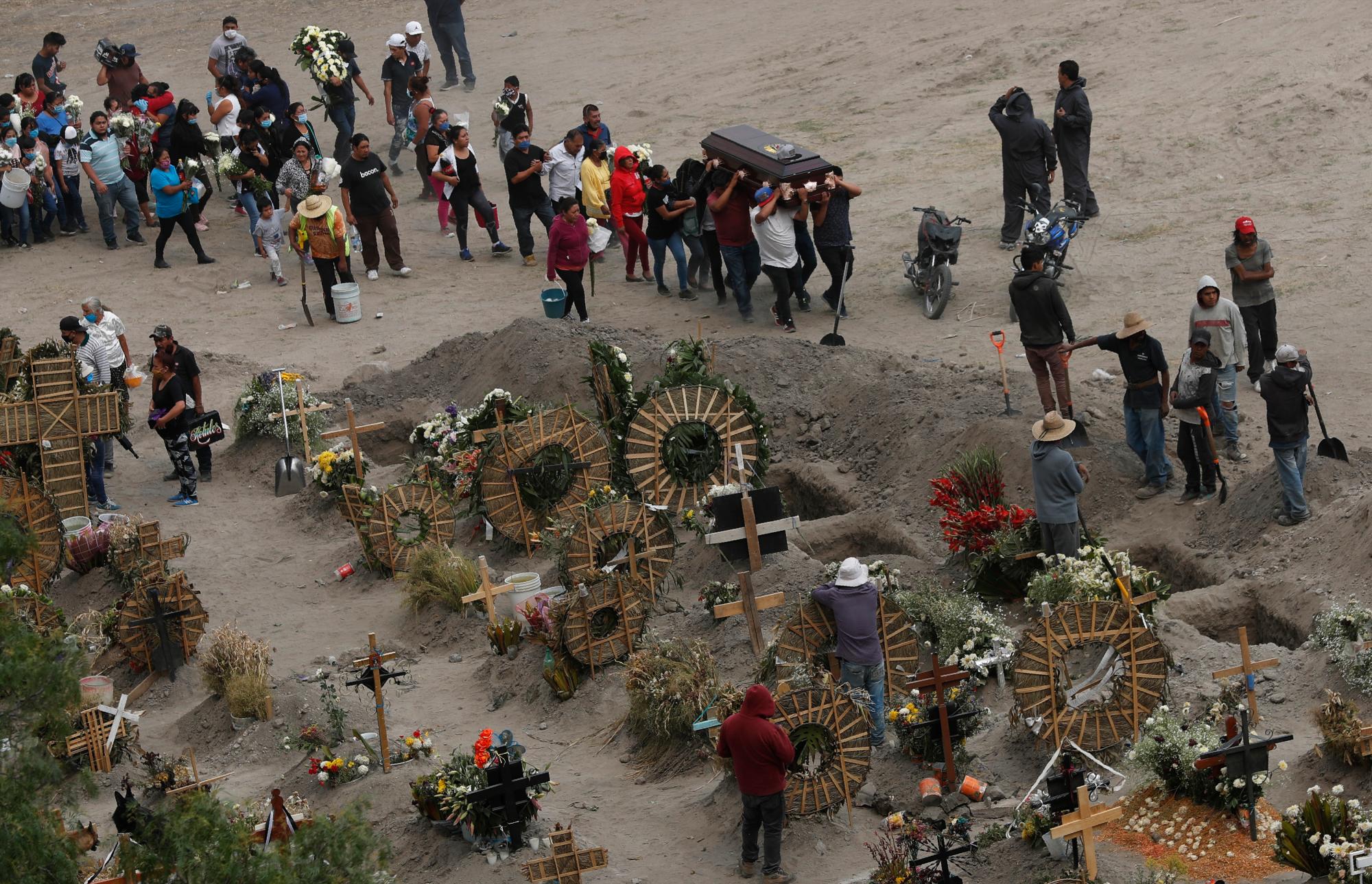 Los familiares llevan el ataúd que contiene los restos de un miembro de la familia, en el recién construido Cementerio Municipal del Valle de Chalco, construido para dar cabida al aumento de las muertes en medio de la nueva pandemia de coronavirus, en el Valle de Chalco, en las afueras de la Ciudad de México, el jueves 21 de mayo. 2020. (Foto AP / Marco Ugarte)