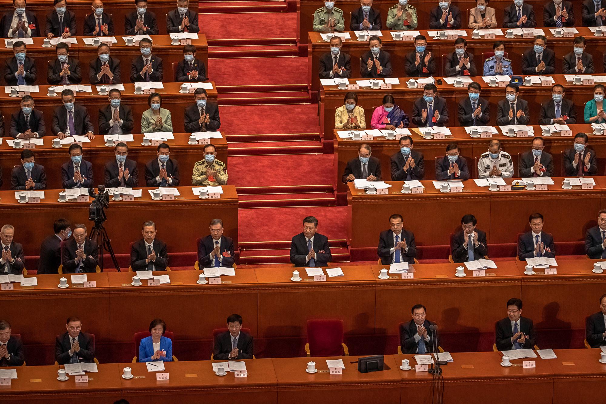 El presidente chino, Xi Jinping, centro, y el primer ministro Li Keqiang, cuarto a la derecha en la segunda fila, con otros delegados asisten a la segunda sesión plenaria del Congreso Nacional del Pueblo (APN) de China en el Gran Salón del Pueblo en Beijing el lunes 25 de mayo de 2020. (Roman Pilipey / Pool Photo vía AP)