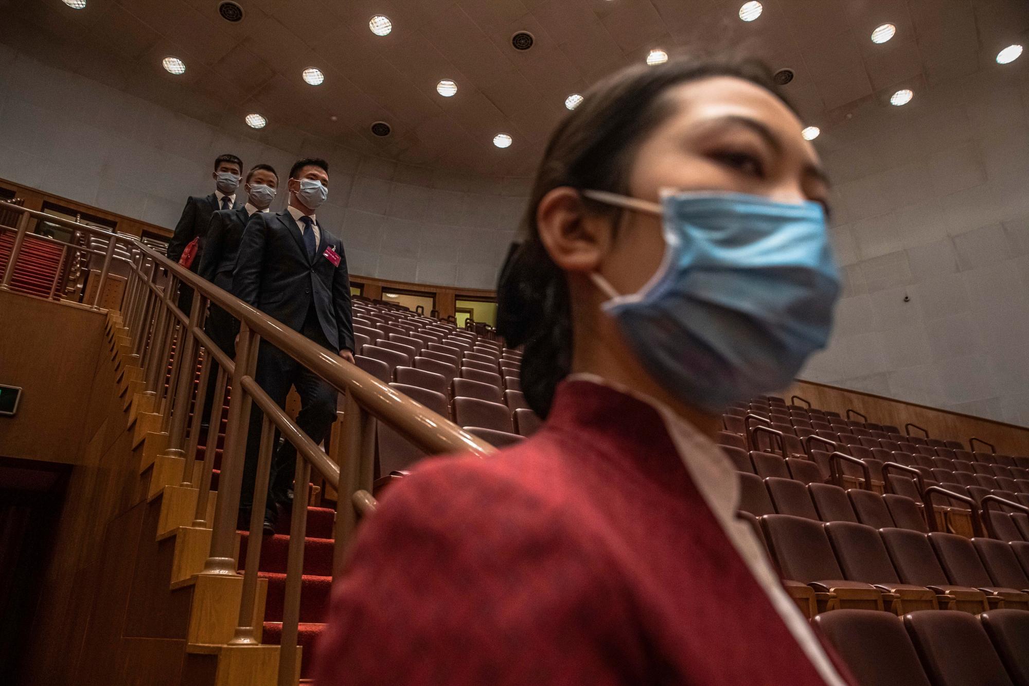Los funcionarios de seguridad y un asistente con máscaras protectoras se van después de la segunda sesión plenaria del Congreso Nacional del Pueblo (APN) de China en el Gran Salón del Pueblo en Beijing, el lunes 25 de mayo de 2020. (Roman Pilipey / Pool Photo vía AP)