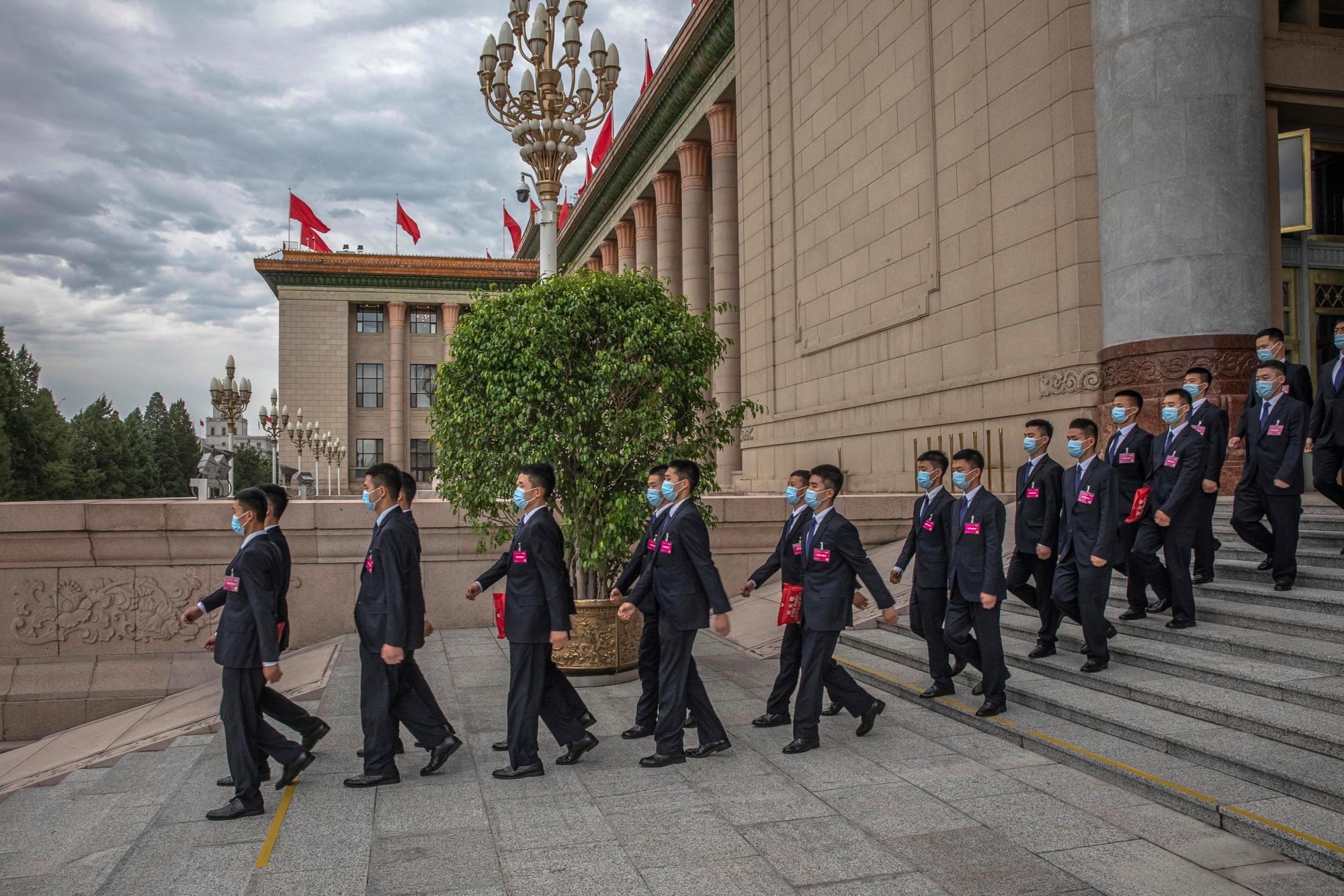 Funcionarios de seguridad con máscaras faciales protectoras marchan después de la segunda sesión plenaria del Congreso Nacional del Pueblo de China (APN) en el Gran Salón del Pueblo en Beijing, el lunes 25 de mayo de 2020. (Roman Pilipey / Pool Photo vía AP)