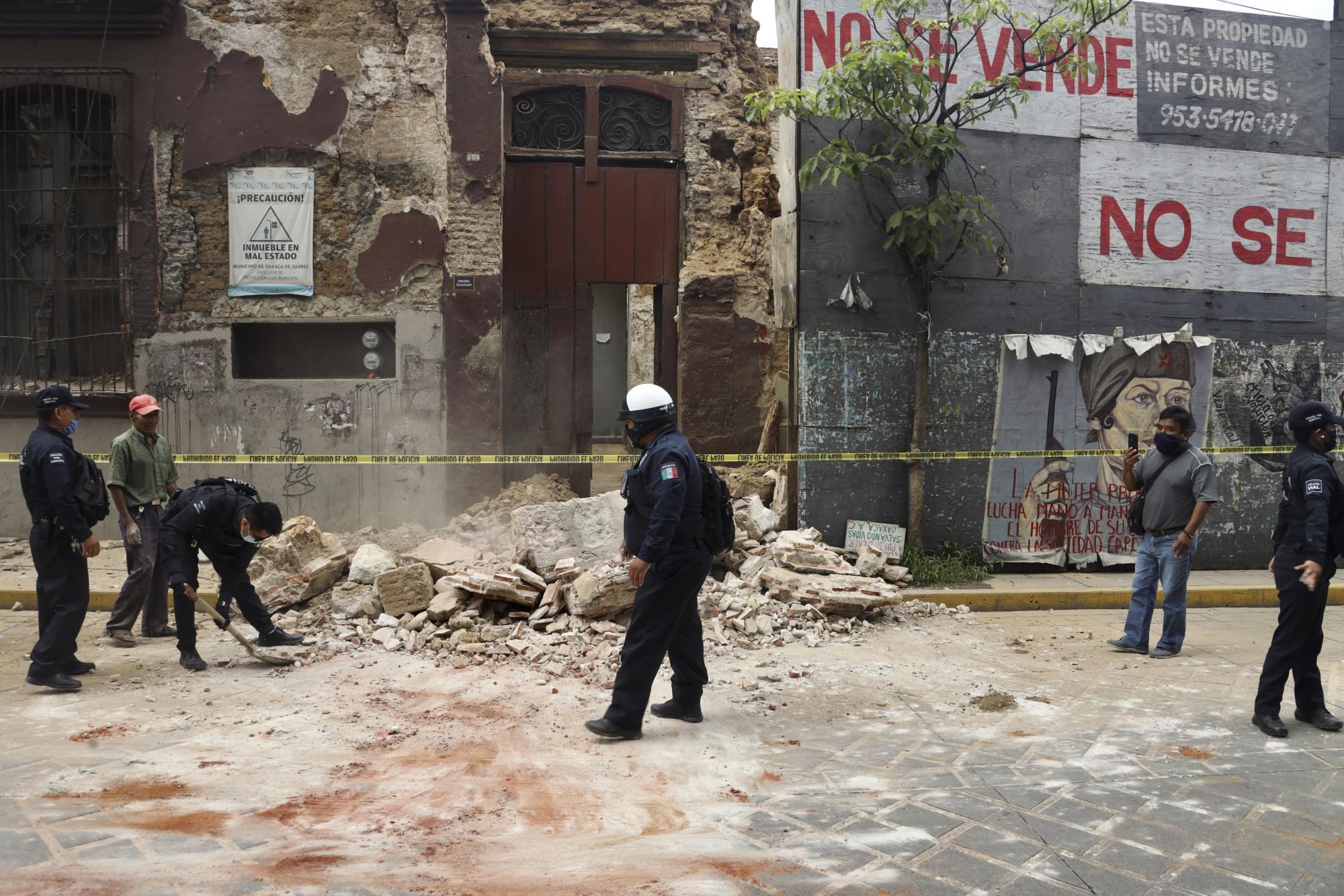 Un policía ayuda a remover los escombros de una edificación en el centro de Oaxaca (AP Photo/Luis Alberto Cruz Hernandez)