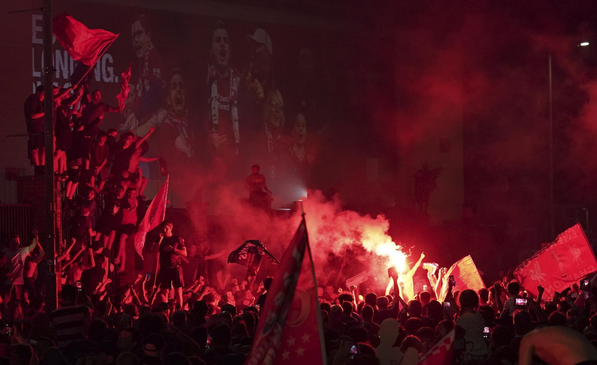 Con fuegos artificiales y bengalas celebraron los fanáticos del Liverpool en las afueras del Anfield Stadium durante la celebración decimonoveno título de su club en la liga inglesa  (AP photo/Jon Super)