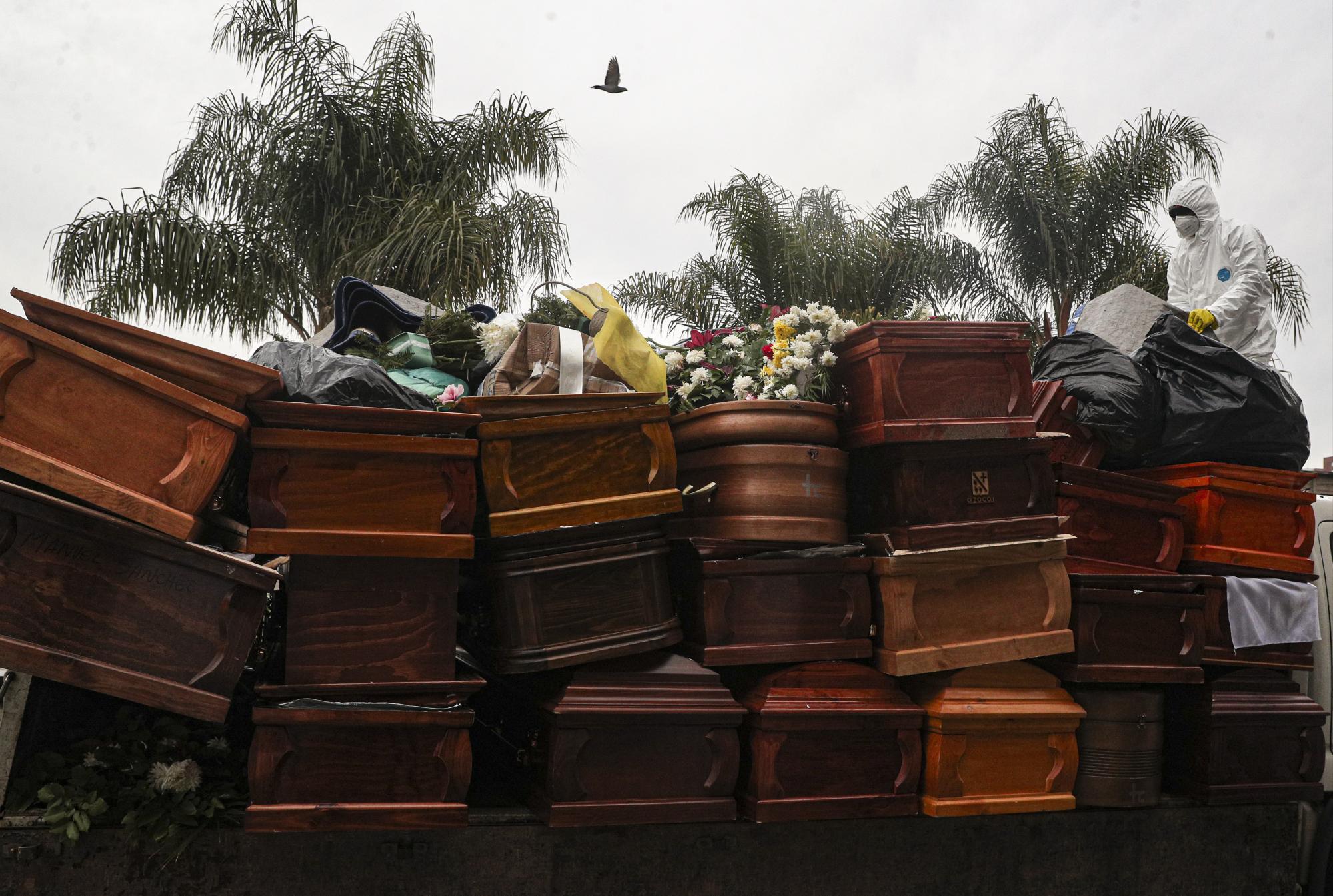 Trabajadores recolectan y apilan ataúdes de personas recientemente cremadas en medio de la pandemia del nuevo coronavirus en el cementerio La Recoleta en Santiago, Chile, el lunes 6 de julio de 2020. (AP Foto/Esteban Felix)