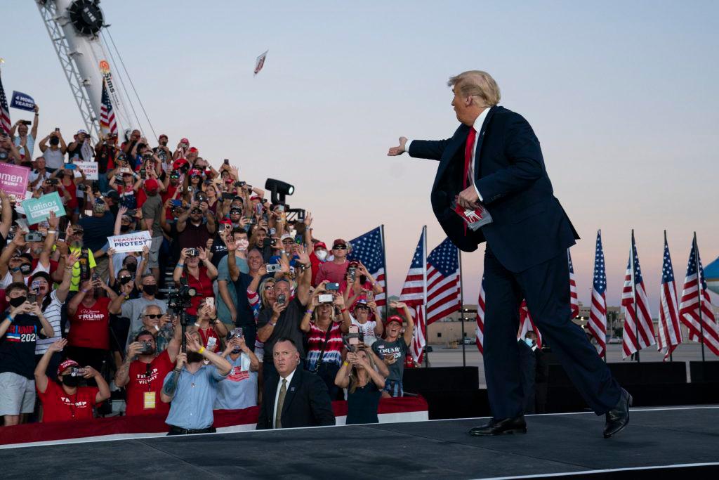 El presidente Donald Trump arroja máscaras a la multitud a su llegada a un mitin de campaña en el Aeropuerto Internacional Orlando Sanford.