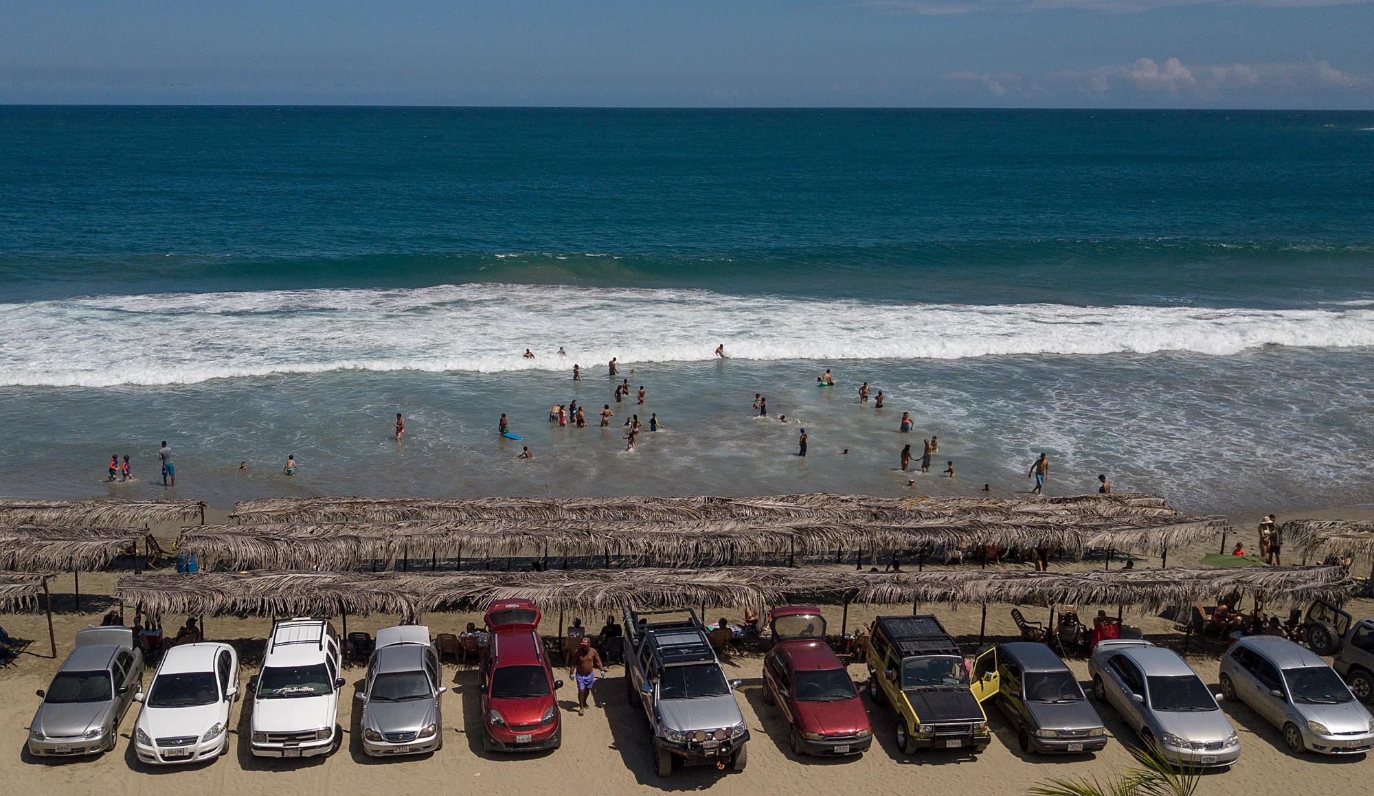 Una fila de carros están estacionados frente la playa Los Ángeles después de su reciente reapertura después de una cuarentena para enfrentar la pandemia del nuevo coronavirus en La Guaira, Venezuela, el viernes 23 de octubre de 2020. 