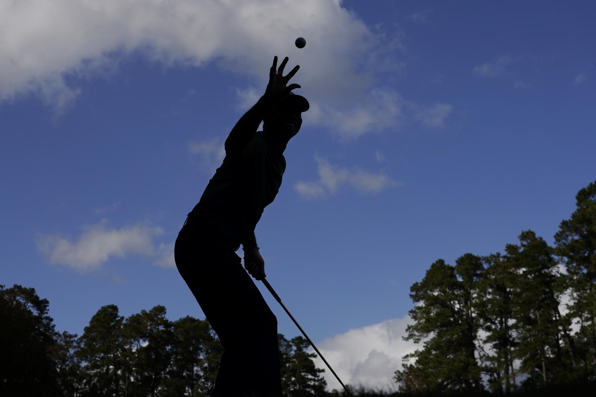 Tiger Woods atrapa una pelota lanzada por su caddie en el Master de Augusta (AP Photo/Charlie Riedel)