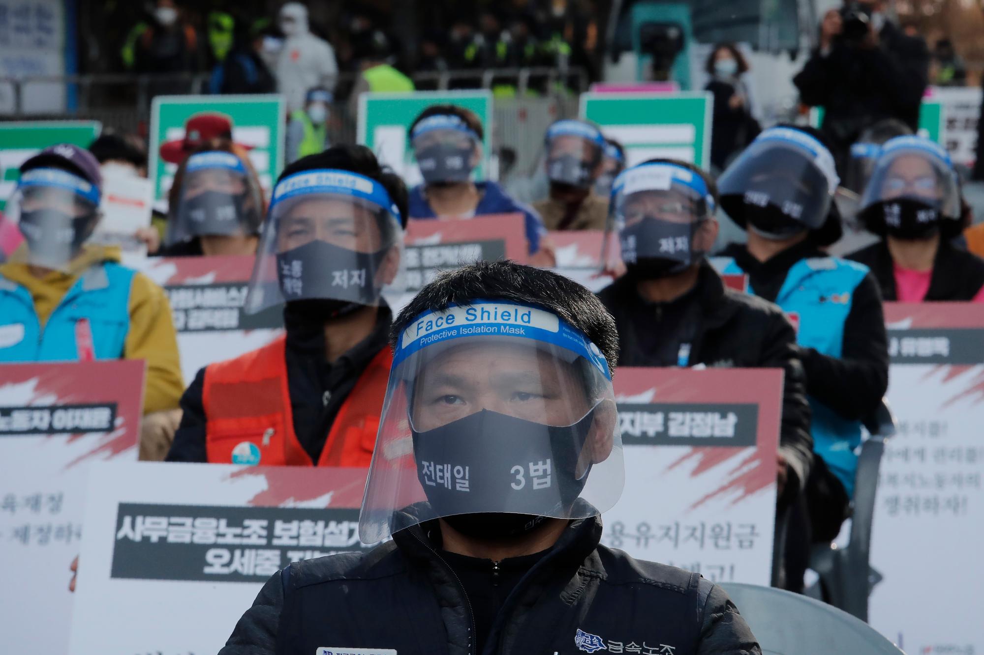 Brote de virus, vida cotidiana en Corea del Sur. Los trabajadores que usan máscaras y escudos para ayudar a protegerse contra la propagación del coronavirus asisten a una manifestación para exigir mejores condiciones laborales en Seúl, Corea del Sur, el sábado 14 de noviembre de 2020.
