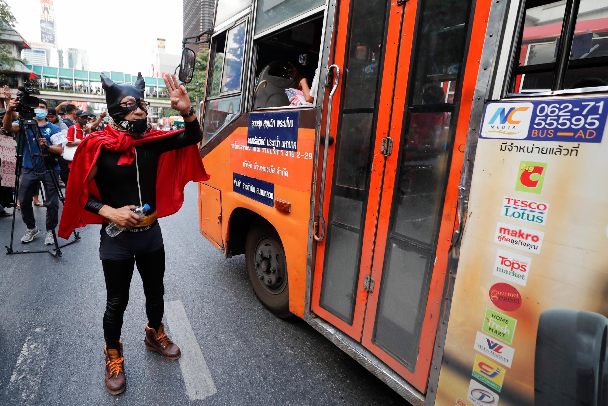 Un manifestante prodemocracia vestido con un traje muestra el saludo de protesta de tres dedos en una importante intersección en Bangkok, Tailandia, el miércoles 18 de noviembre de 2020. La policía en la capital de Tailandia se preparó para posibles problemas el miércoles, un día después de una protesta frente al Parlamento por Los manifestantes a favor de la democracia se vieron empañados por la violencia que dejó decenas de heridos. 
