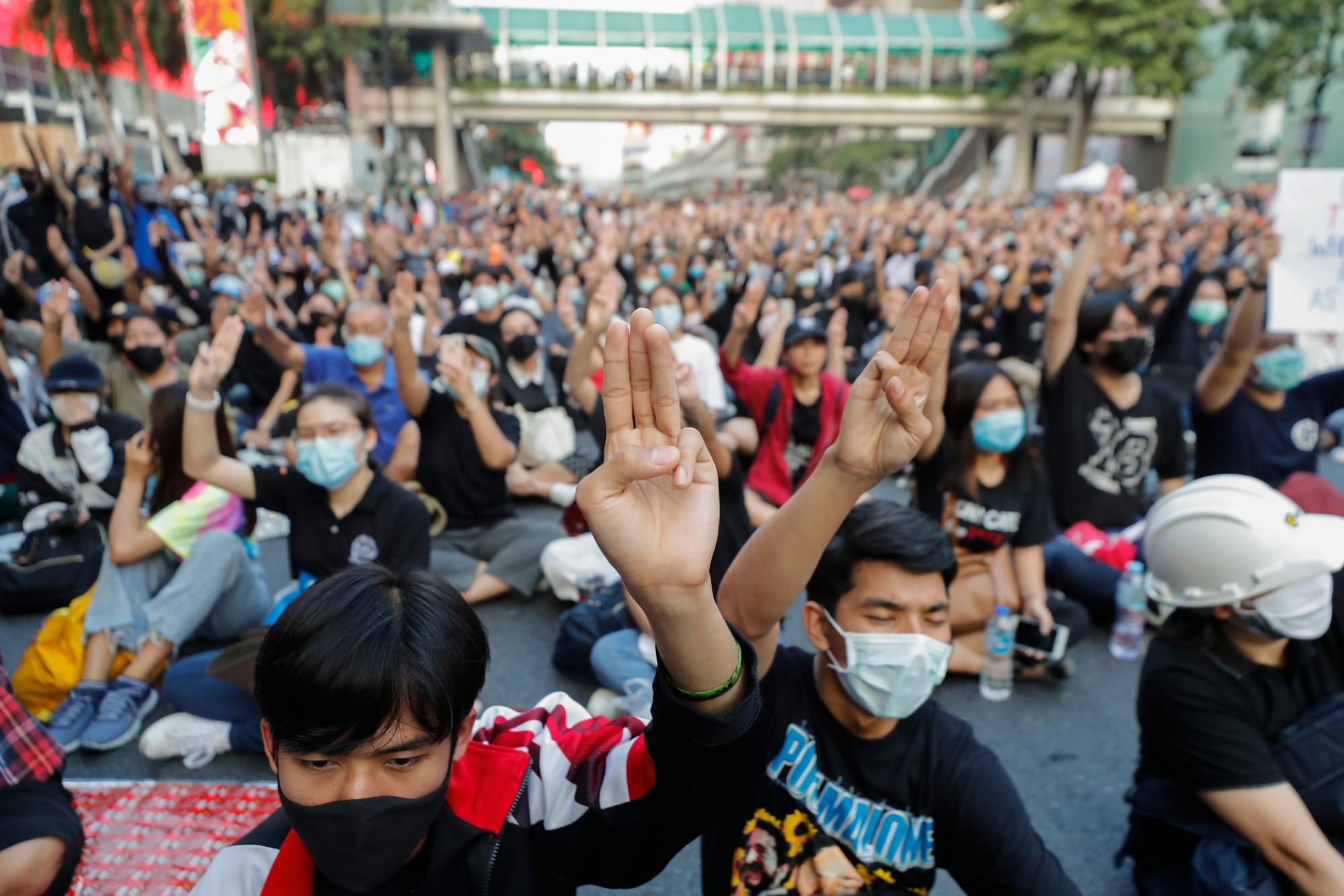 Manifestantes a favor de la democracia muestran el saludo de protesta de tres dedos durante una manifestación contra el gobierno en una importante intersección en Bangkok, Tailandia, el miércoles 18 de noviembre de 2020. La policía en la capital de Tailandia se prepara para posibles problemas el miércoles, un día después de una protesta en el exterior El parlamento de manifestantes a favor de la democracia se vio empañado por la violencia que dejó decenas de heridos. 