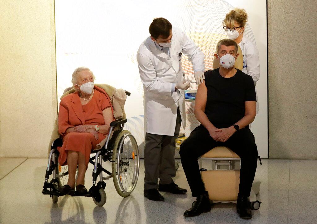La veterana de la Segunda Guerra Mundial, Emilie Repikova, a la izquierda, observa cómo el primer ministro de la República Checa, Andrej Babis, recibe una vacuna contra el COVID-19 en el hospital militar de Praga, República Checa, el domingo 27 de diciembre de 2020.