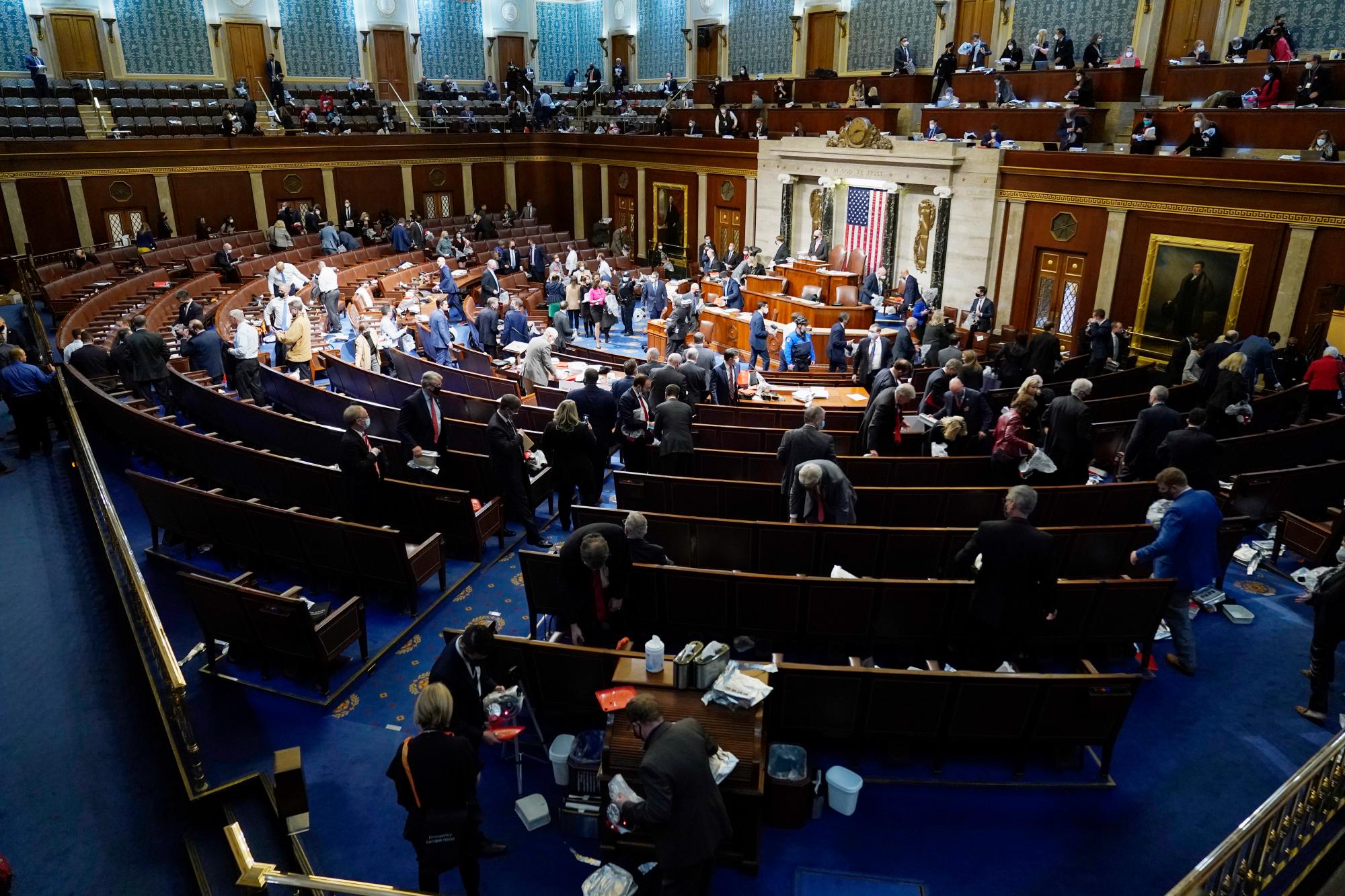 Los miembros de la Cámara de Representantes se preparan para dejar el piso mientras los manifestantes intentan ingresar a la Cámara de la Cámara en el Capitolio de los Estados Unidos el miércoles 6 de enero de 2021 en Washington.