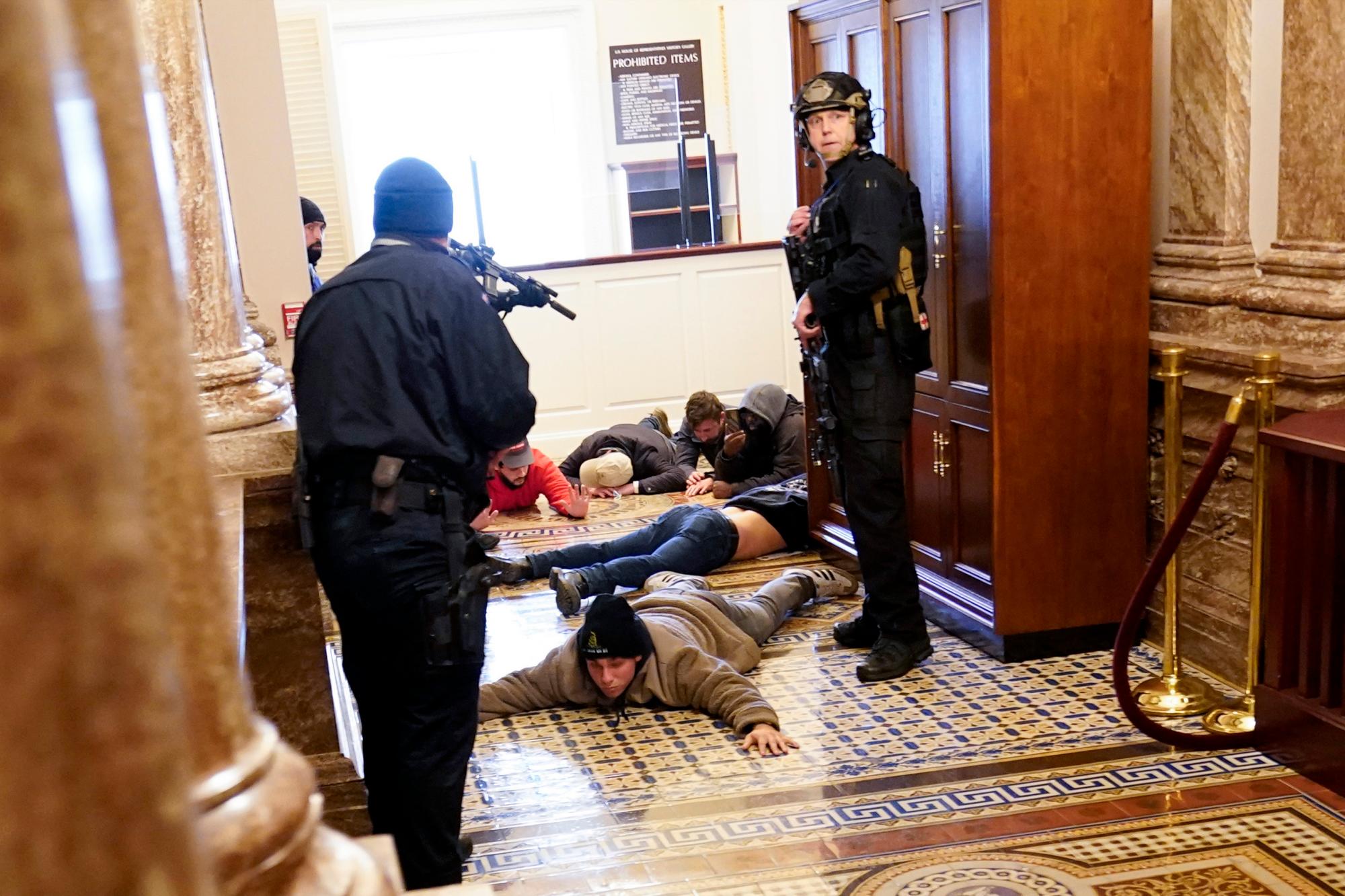 La Policía del Capitolio de los Estados Unidos detiene a los manifestantes a punta de pistola cerca de la Cámara de la Cámara dentro del Capitolio de los Estados Unidos el miércoles 6 de enero de 2021 en Washington.