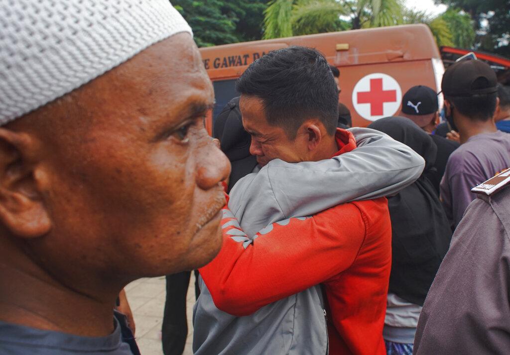 Dos hombres indonesios se consuelan en medio del desastre causado por un terremoto que sacudió la localidad de Mamuju en Indonesia (AP Photo/Azhari Surahman)