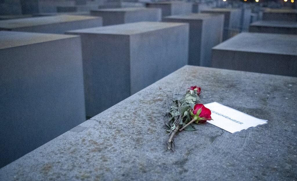 Una rosa y un mensaje en el que se lee la frase Nosotros recordamos descansa sobre el Memorial por las víctimas del Holocausto en la ciudad de Berlín (Dorothee Barth/dpa via AP).