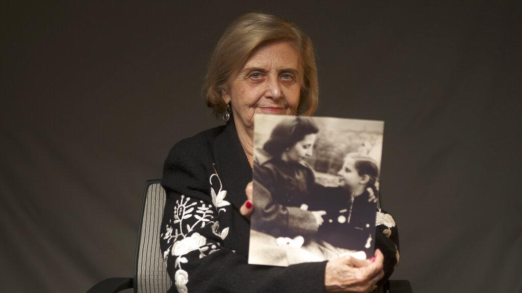 Tova Friedman, una mujer de 82 años sobreviviente del holocausto, sostiene una fotografía  en la que aparece junto a su madre, quien también salió con vida del campo de la muerte de Auschwitz (World Jewish Congress via AP).