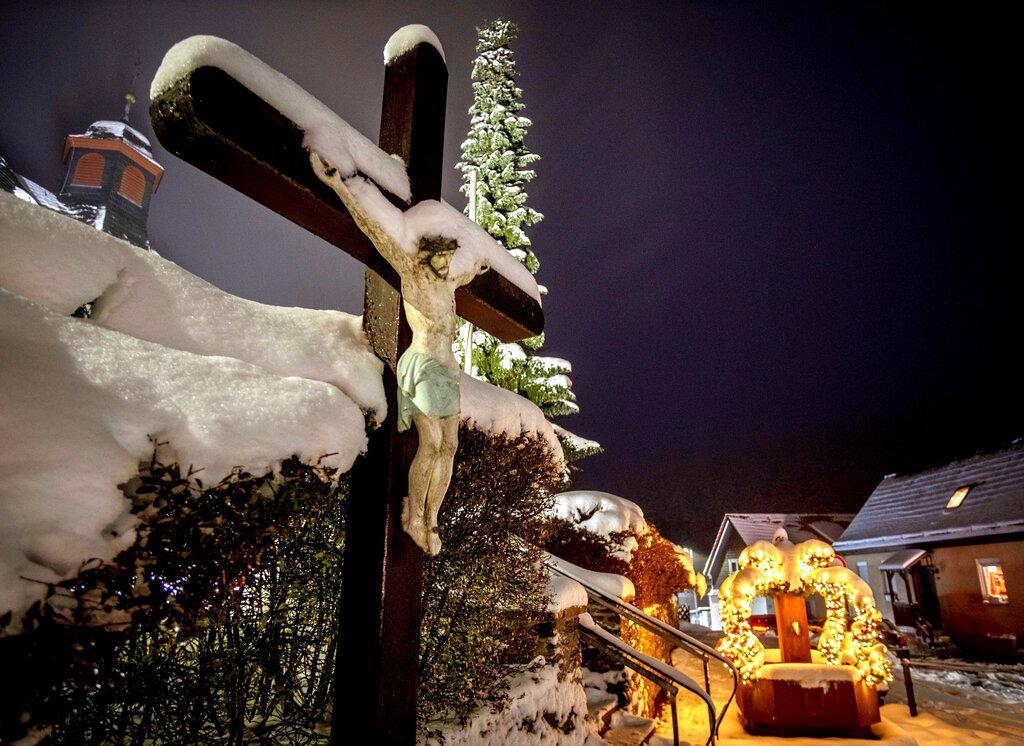 Una figura de Jesús Cristo cubierta de nieve vigila el sueño de los habitantes de Seelenberg en las afueras de Frankfurt, Alemania. (AP Photo/Michael Probst)