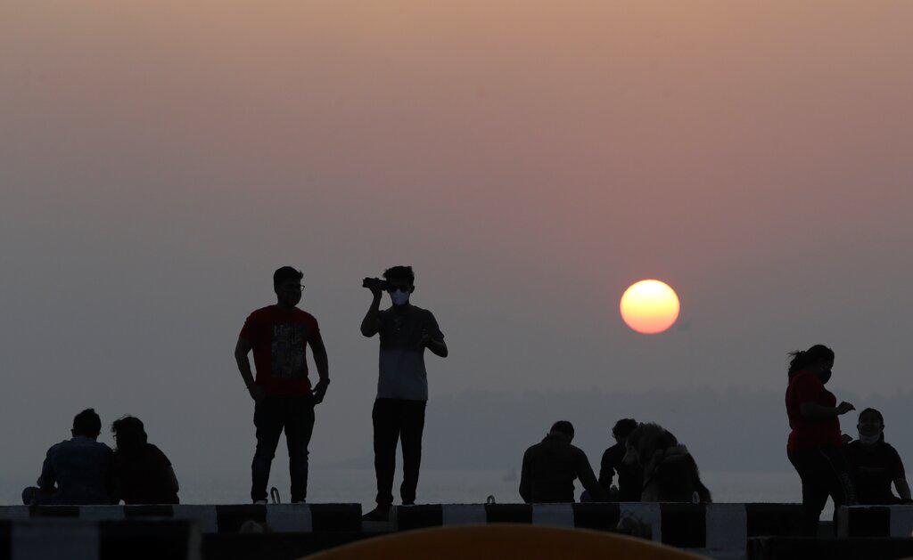 Un grupo de personas contempla el atardecer sobre el Mar Arábigo (AP Photo/Rajanish Kakade)