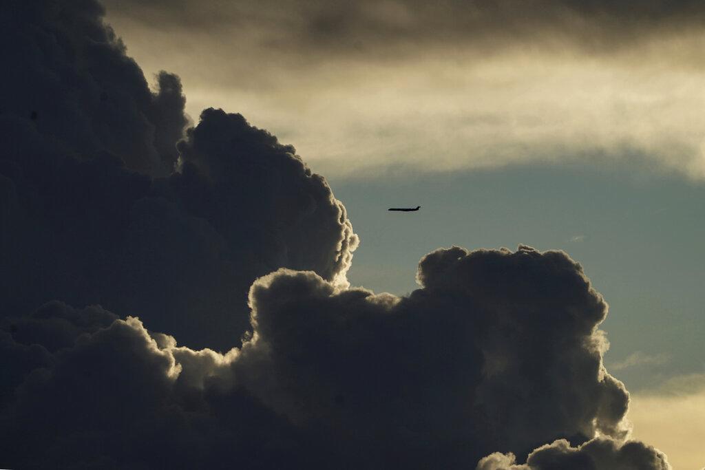 Un avión que vuela sobre el cielo de Lyon, en Francia, ingresa a cúmulo de nubes al caer la tarde  (AP Photo/Laurent Cipriani)