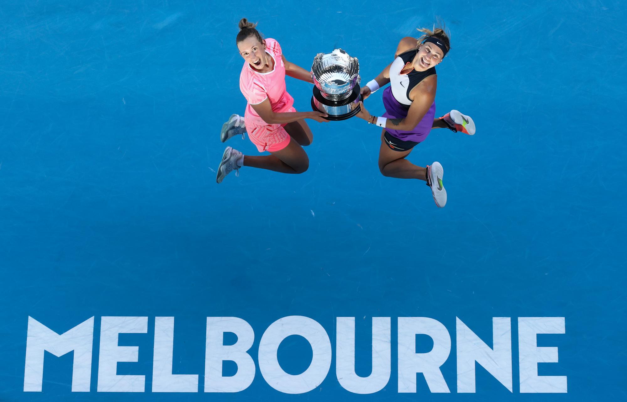 La belga Elise Mertens, izquierda, y Aryna Sabalenka de Bielorrusia celebran con su trofeo después de derrotar a Barbora Krejcikova y Katerina Siniakova de la República Checa en la final de dobles femeninos en el campeonato de tenis del Abierto de Australia en Melbourne, Australia, el viernes 19 de febrero de 2021.