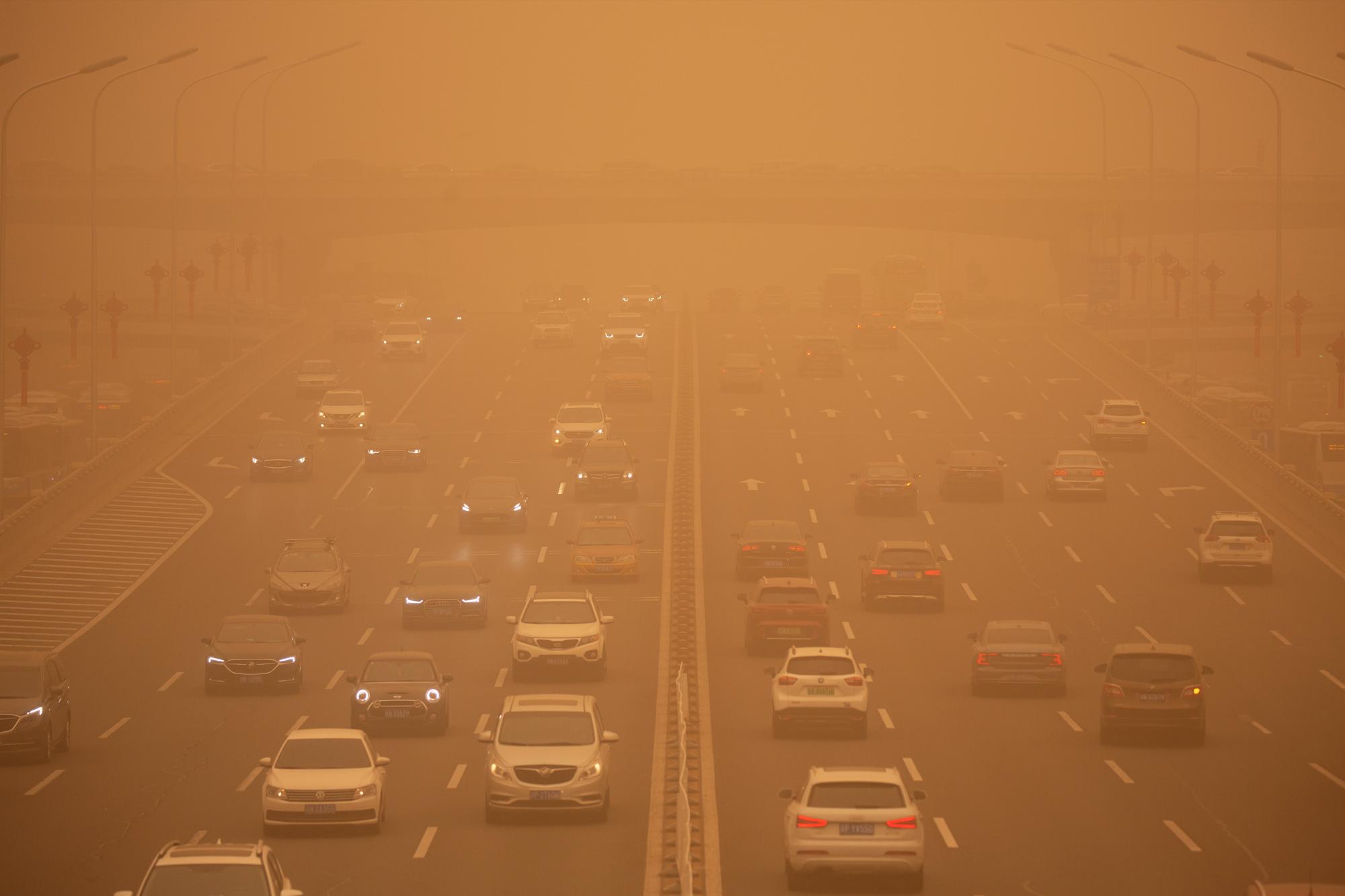 Los automóviles circulan por una autopista en medio de una tormenta de arena durante la hora pico de la mañana en Beijing, el lunes 15 de marzo de 2021. La tormenta de arena trajo una neblina teñida a los cielos de Beijing y elevó los índices de calidad del aire el lunes. (AP Photo/Mark Schiefelbein)