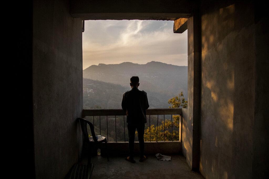 Un oficial de policía que escapó de Myanmar después del golpe militar, observa las montañas en una zona no determinada de la frontera de ese país con La India. (AP Photo/Anupam Nath)