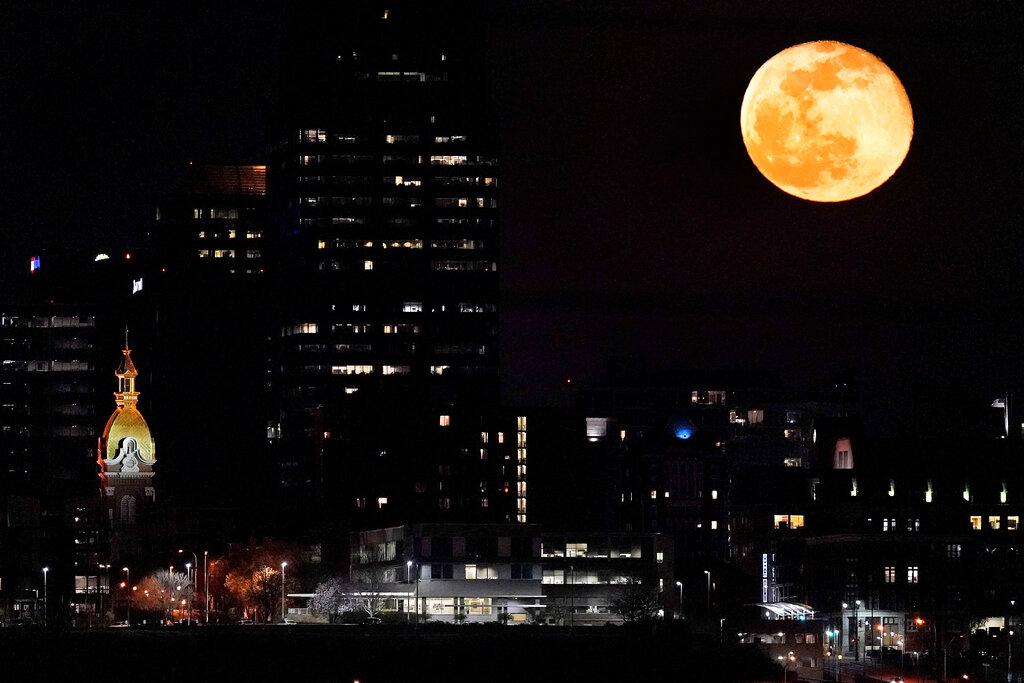 La luna en todo se esplendor sobre la silueta de Kansas City, Missouri.  (AP Photo/Charlie Riedel)