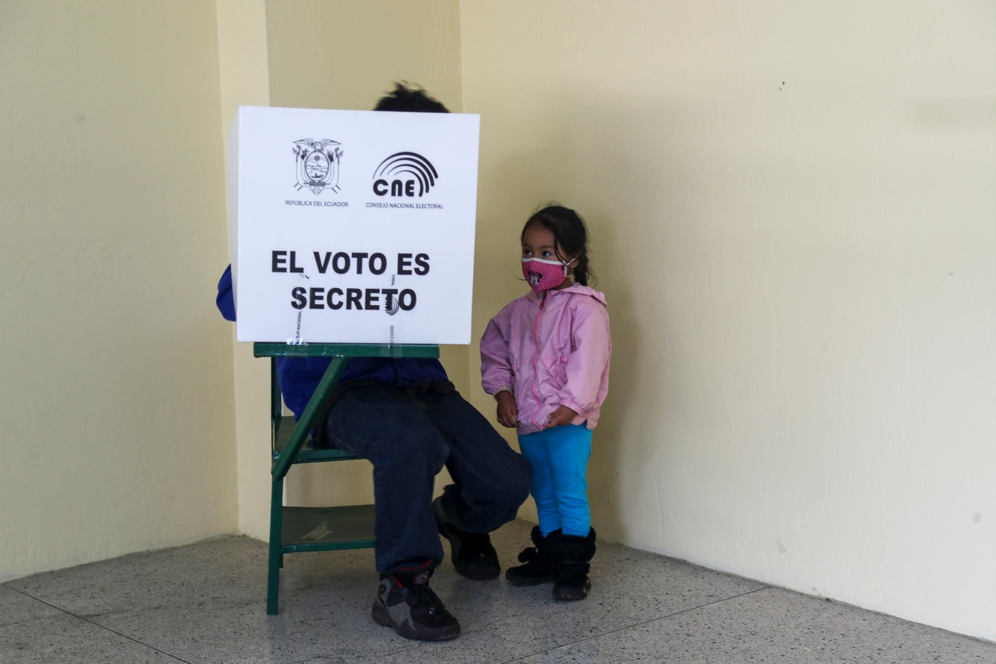Un votante, acompañado de su hija, marca su boleta durante la segunda vuelta de las elecciones presidenciales en Quito, Ecuador, el domingo 11 de abril de 2021. Los ecuatorianos están votando, en medio de la pandemia de COVID-19, para elegir entre Andrés Arauz, de la coalición Unión de la Esperanza y un economista protegido del expresidente Rafael Correa, y el exbanquero Guillermo Lasso, del partido Creando Oportunidades o CREO. 