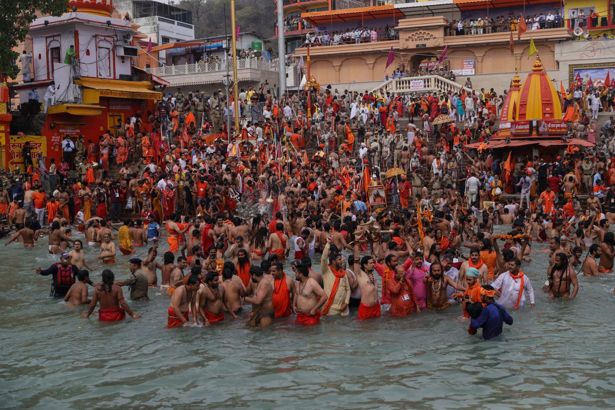Los devotos toman baños sagrados en el río Ganges durante el Kumbh Mela, o festival de jarras, una de las peregrinaciones más sagradas del hinduismo, en Haridwar, estado norteño de Uttarakhand, India, el lunes 12 de abril de 2021. Decenas de miles de devotos hindúes se reunieron por el río Ganges para oraciones especiales el lunes, muchas de ellas burlando las prácticas de distanciamiento social a medida que el coronavirus se propaga en la India a una velocidad récord. (AP Photo/Karma Sonam)