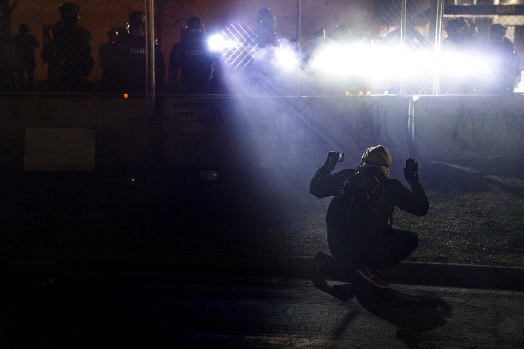 La policía ilumina a un sujeto que participó en las protestas que ocurrieron tras la muerte del joven Daunte Wright, en las afueras de la estación policial de Brooklyn Center de Minneapolis.  (AP Photo/John Minchillo)