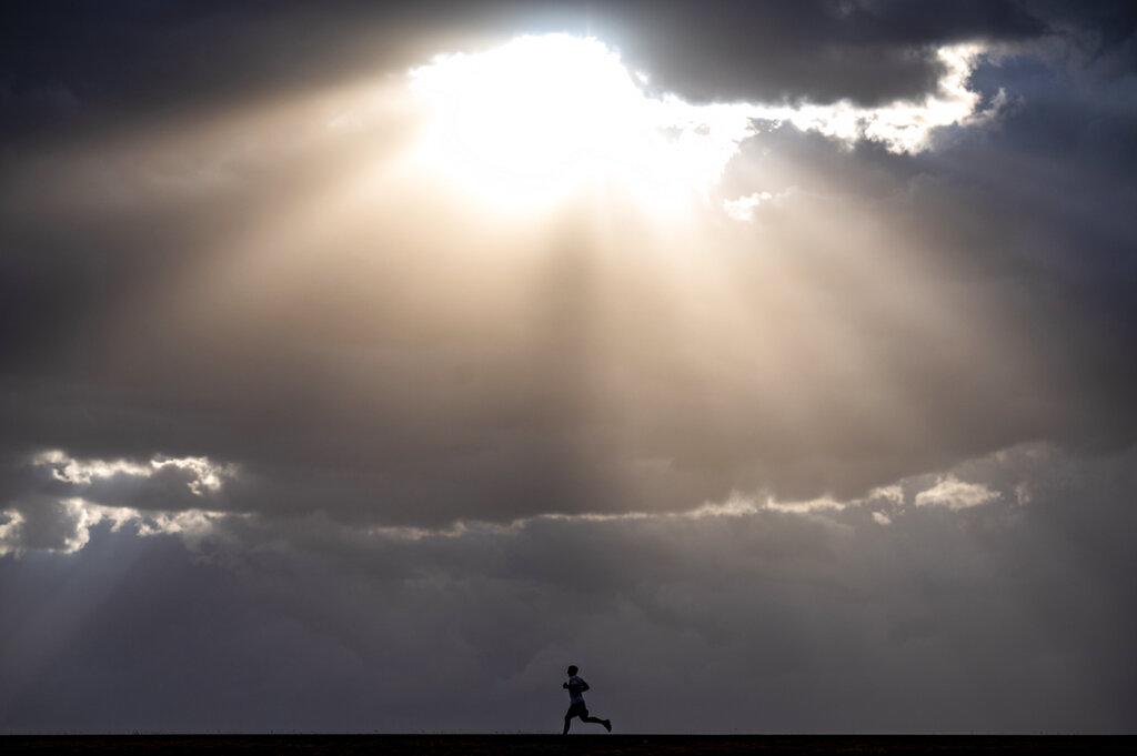 Un corredor solitario disfrutó de una vista espectacular cuando el sol salió detrás de las nubes que cubrían el cielo del Lewiston Levee Parkway, en Idaho. (Pete Caster/Lewiston Tribune via AP)