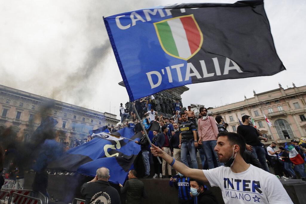 Hinchas del Inter de Milán celebran en la Piazza Duomo luego de que su equipo se convirtiera en el nuevo campeón de la Serie A de Italia, acabando con la hegemonía de la Juventus que había alzado el título de campeón nueve veces de manera consecutiva. El Inter no ganaba la el campeonato desde el 2010. (AP Photo/Luca Bruno)