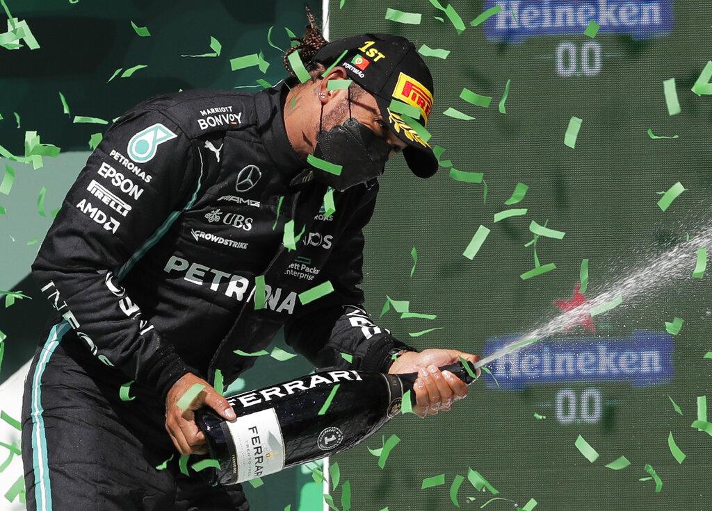 Lewis Hamilton celebró en los más alto de podium del Gran Premio de Portugal de la Fórmula Uno. (AP Photo/Manu Fernandez)