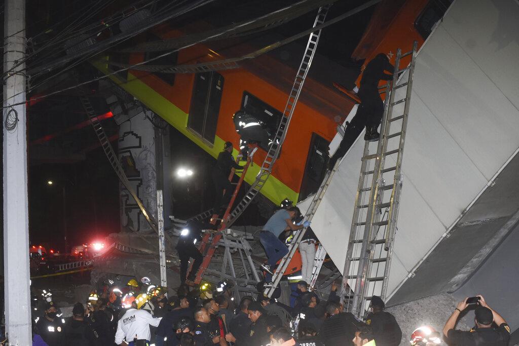 Bomberos de la Ciudad de México realizan labores de rescate en el tren de la línea 12 que cayó varios metros cuando una sección de la vía elevada colapsó dejando un saldo de 23 muertos y 70 heridos. (AP Photo/Jose Ruiz)