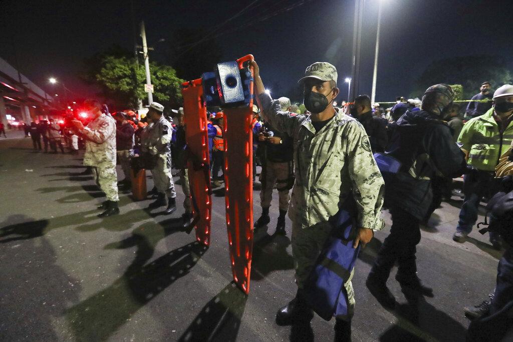 Soldados del ejército de México sostienen camillas mientras esperan para ayudar en los esfuerzos de rescate luego de que una sección de la Línea 12 del metro colapsara en Ciudad de México. (AP Foto/Marco Ugarte)