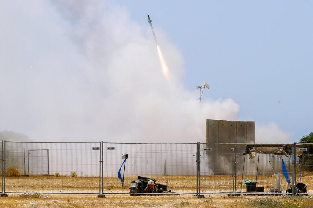 Un soldado israelí se pone a cubierto mientras el sistema de defensa conocido como Domo de hierro dispara un misil para interceptar ataques provenientes de la Franja de Gaza. (AP Photo/Ariel Schalit)