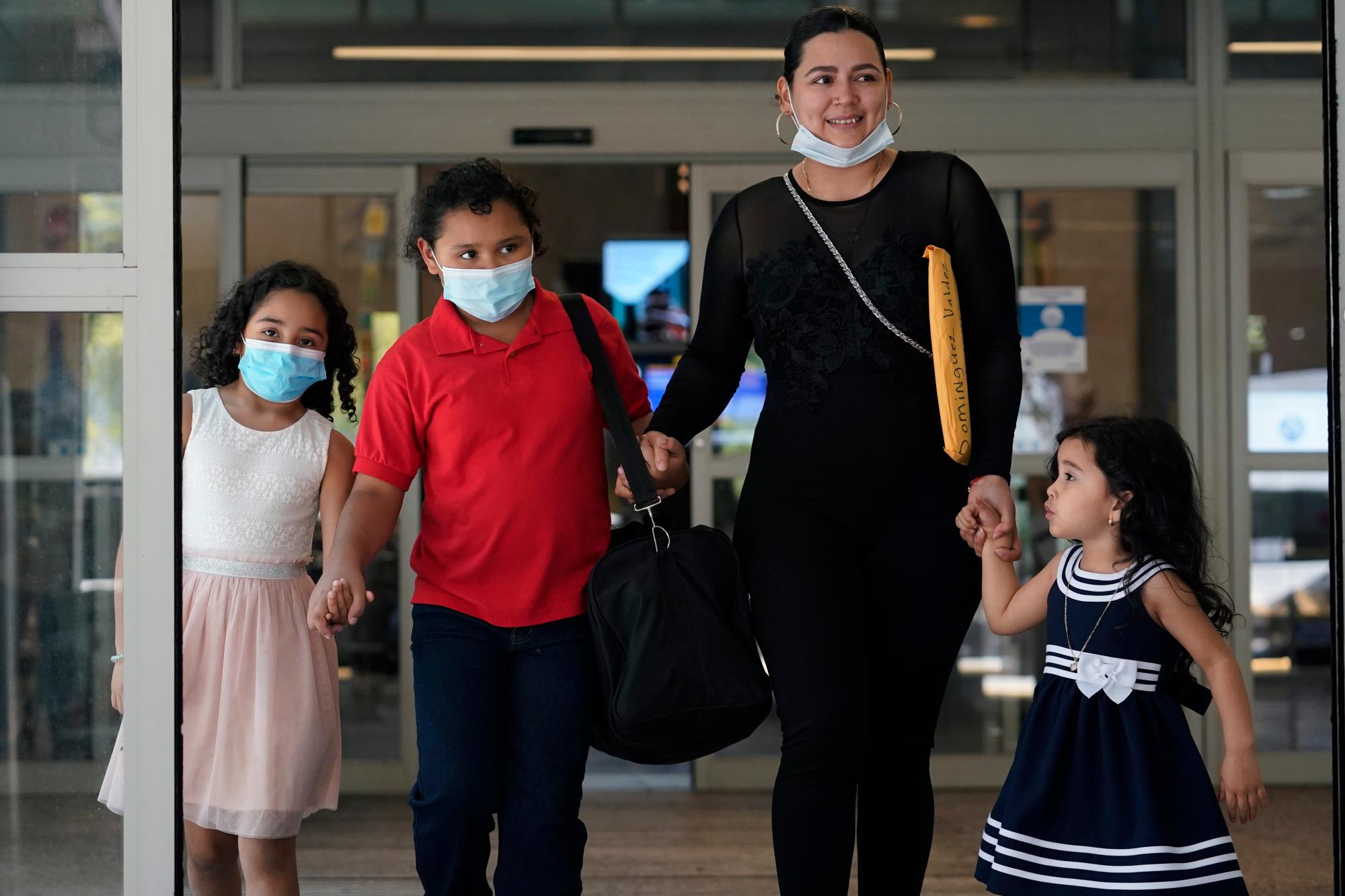 Glenda Valdez sale del aeropuerto de Austin-Bergstrom de Texas tras reunirse con su hija Emely (segunda desde la izq), de nueve años y quien cruzó sola la frontera entre México y EEUU. La acompañan sus otras dos hijas, Jassary (izq) y Zuri. Foto del 6 de junio del 2021.