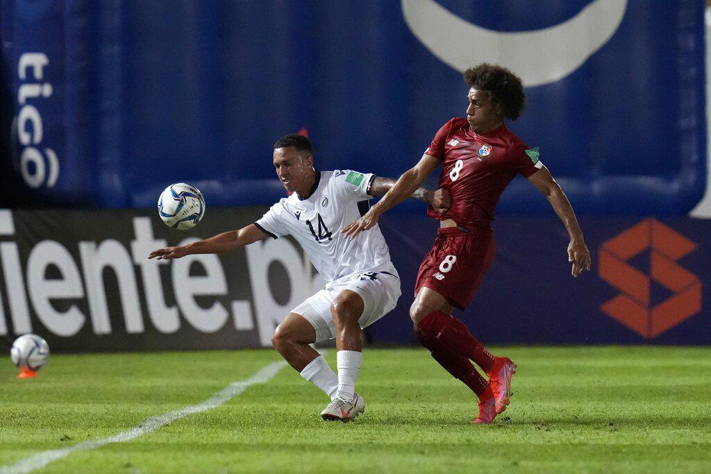 El panameño Adalberto Carrasquilla, a la derecha, y el dominicano Jean Carlos López luchan por el balón durante un partido por las eliminatorias de la CONCACAF a la Copa Mundial de Qatar 2022 en Ciudad de Panamá, el martes 8 de junio de 2021. (AP Foto/Arnulfo Franco)