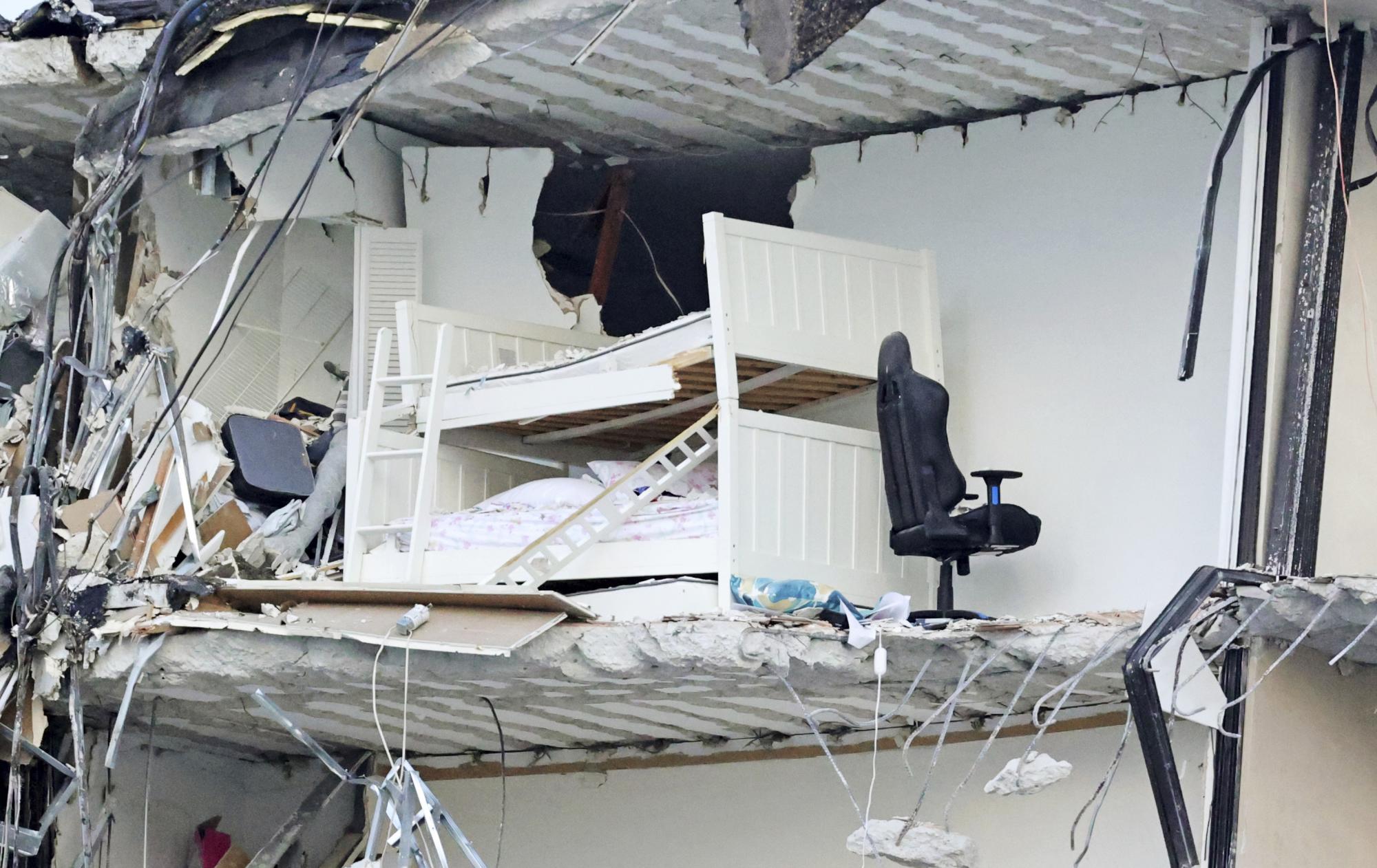 Escombros cuelgan de Champlain Towers South Condo después de que el edificio de varios pisos se derrumbó parcialmente el jueves 24 de junio de 2021 en Surfside, Florida (David Santiago / Miami Herald vía AP)