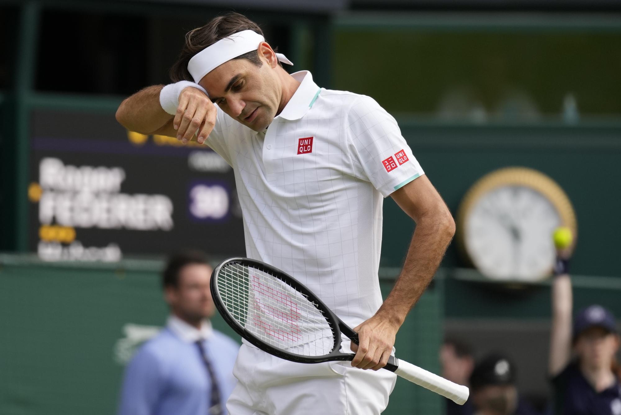 Roger Federer se seca el sudor durante el partido contra Hubert Hurkacz en los cuartos de final de Wimbledon, el miércoles 7 de julio de 2021, en Londres. (AP/Kirsty Wigglesworth)